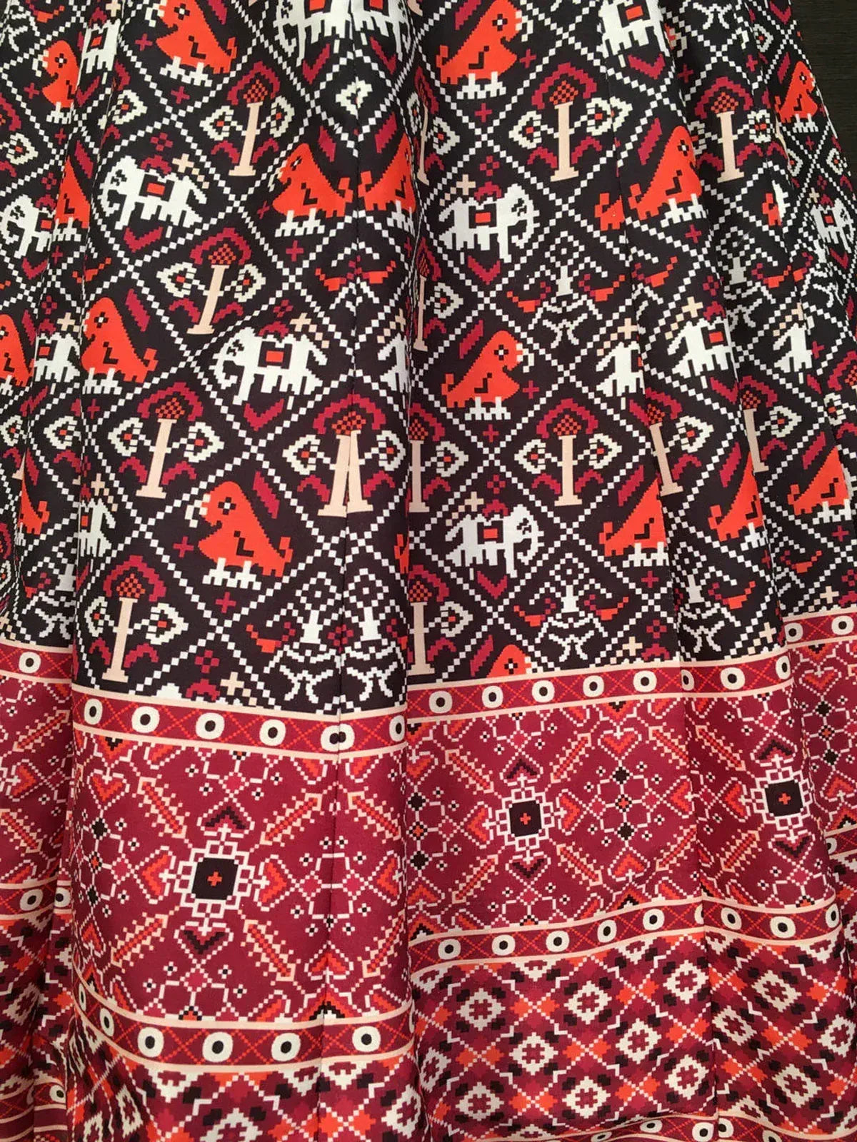 Black and red ethnic lehenga fabric with traditional geometric and elephant print patterns