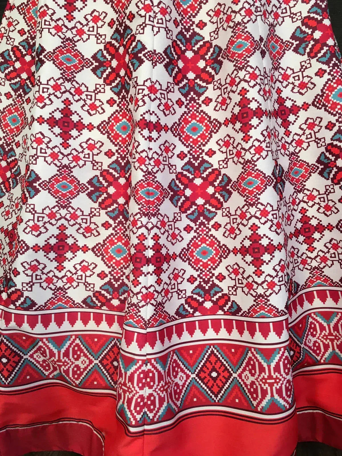 White ethnic skirt with red and turquoise geometric patterns and decorative border