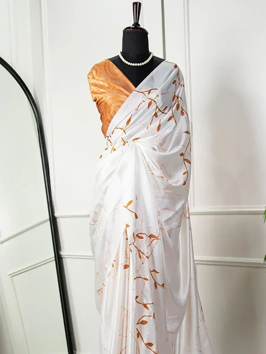 White saree with orange leaf print, styled on mannequin with pearl necklace, ethnic wear