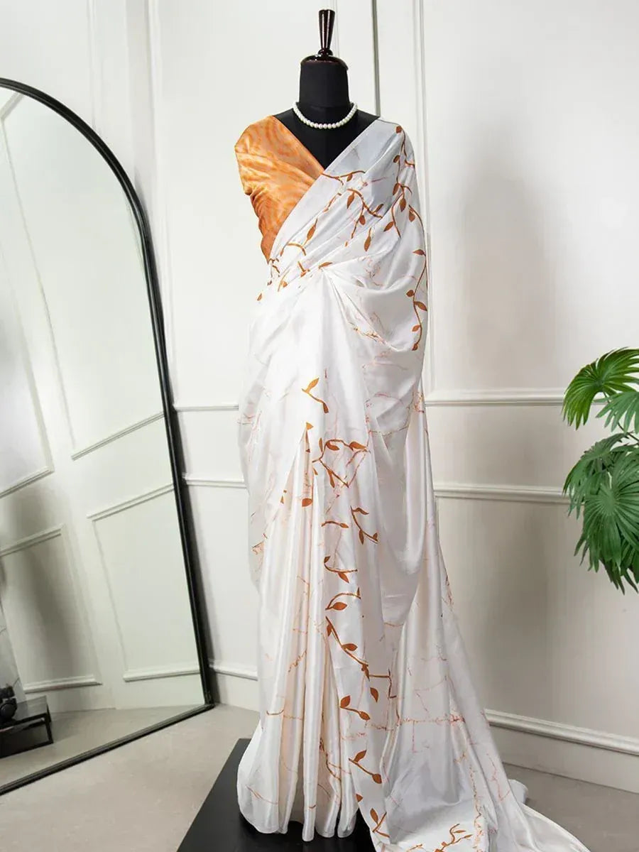 White saree with orange leaf print, styled with matching blouse and pearl necklace for ethnic wear