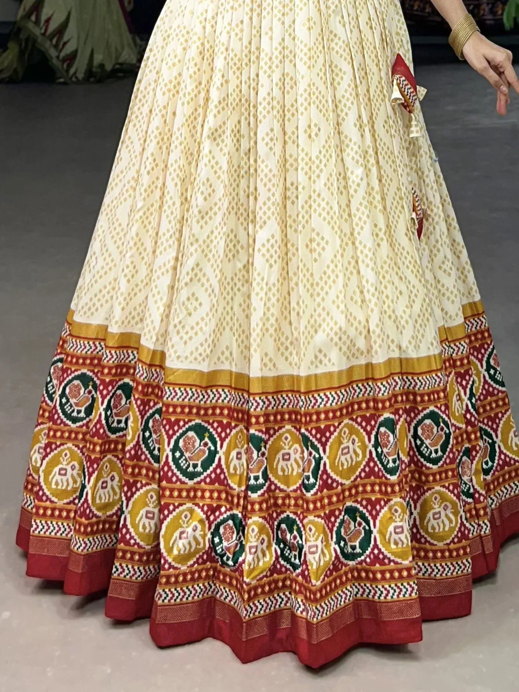 Cream lehenga with red border, elephant and peacock motifs, ethnic Indian wear
