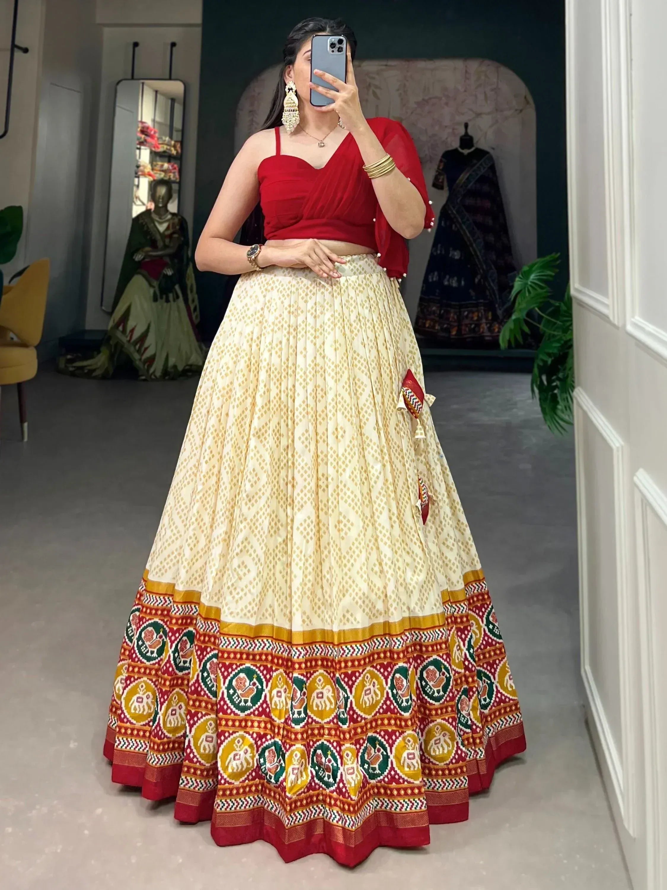 Red crop top with cream pleated lehenga featuring elephant motifs, perfect for Indian ethnic wear