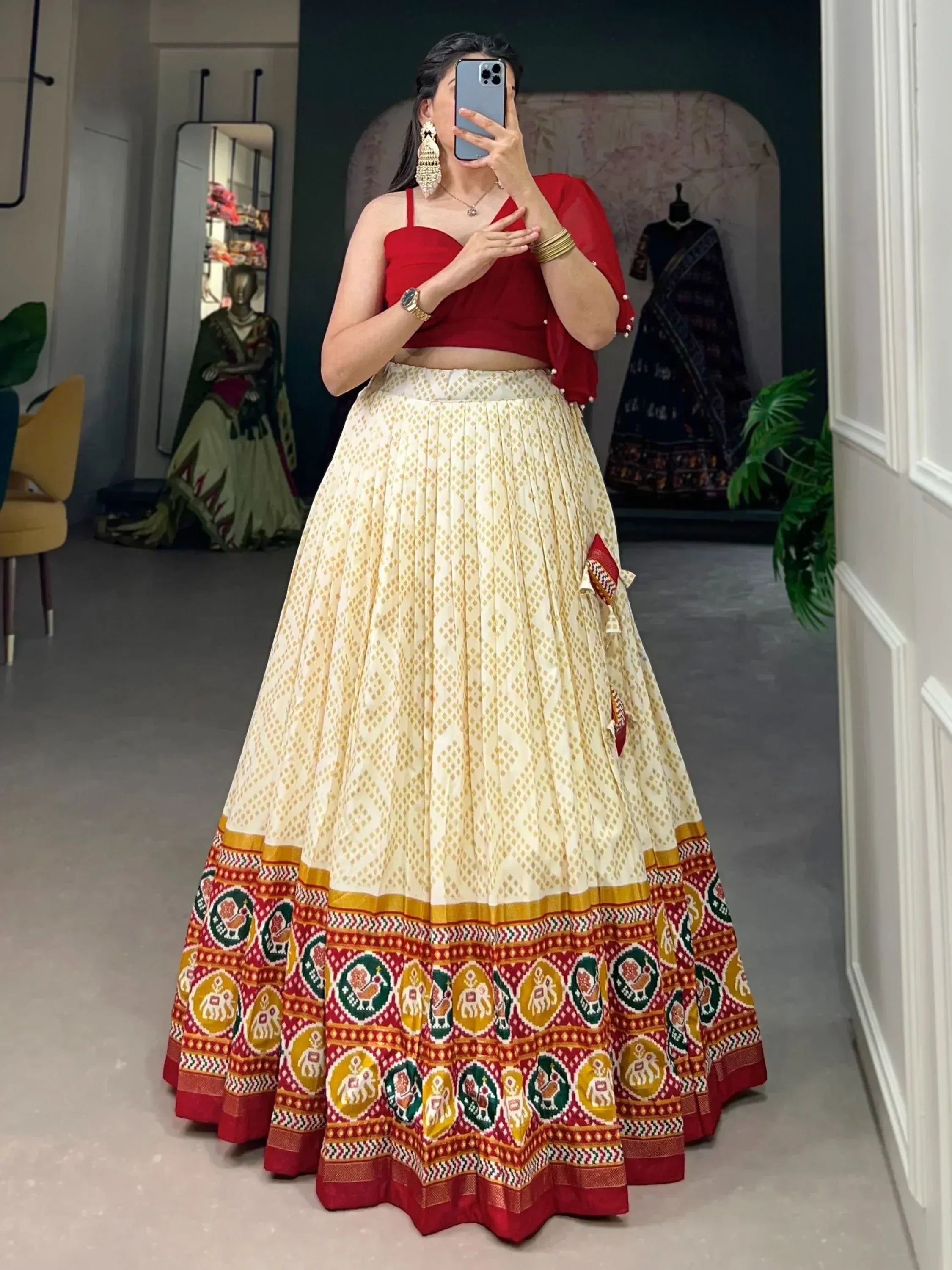 Woman in red crop top and cream lehenga with elephant print, Indian ethnic wear for festive occasions