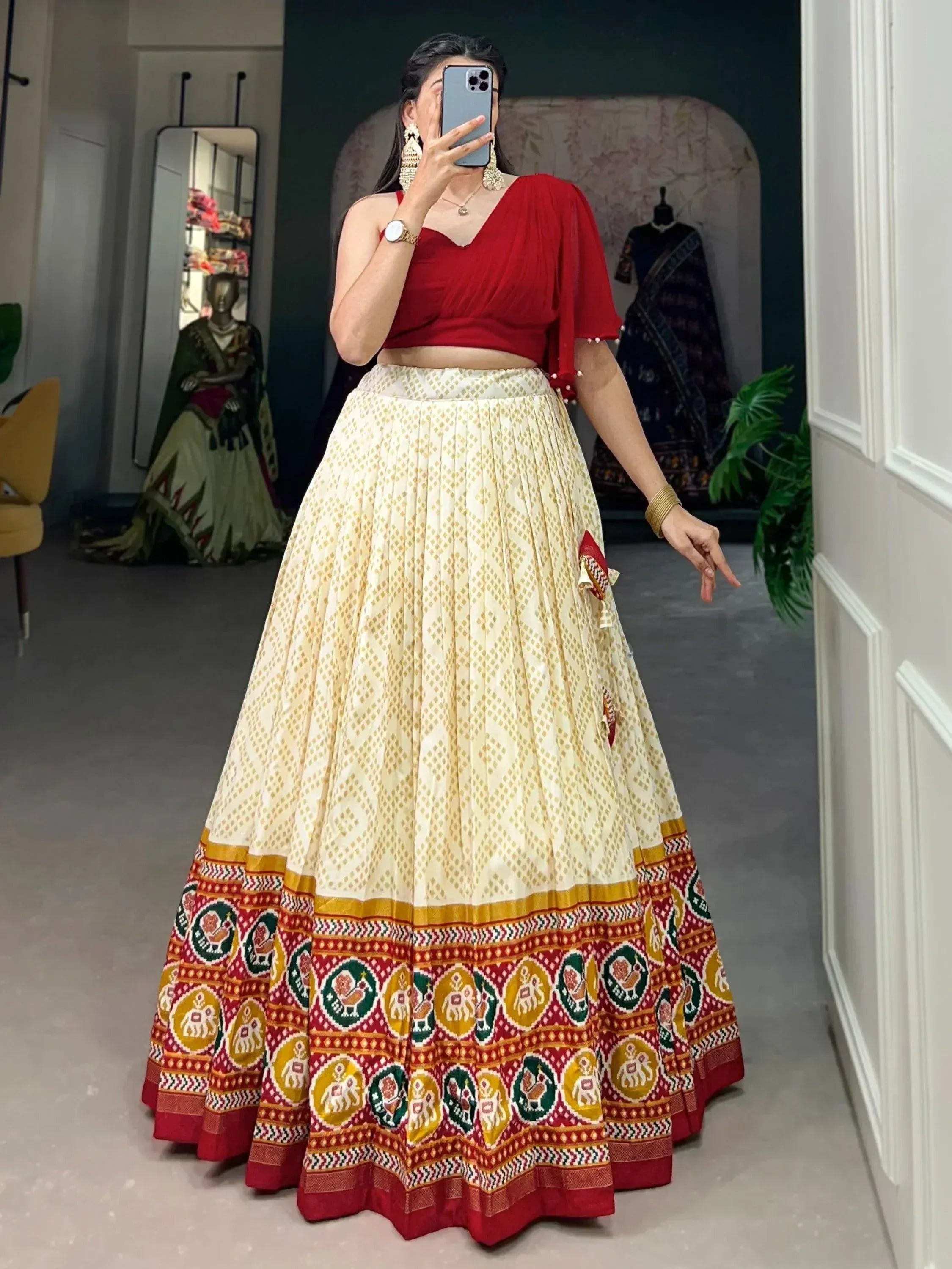 Red crop top with cream pleated lehenga featuring elephant and peacock motifs, perfect for Indian ethnic wear.