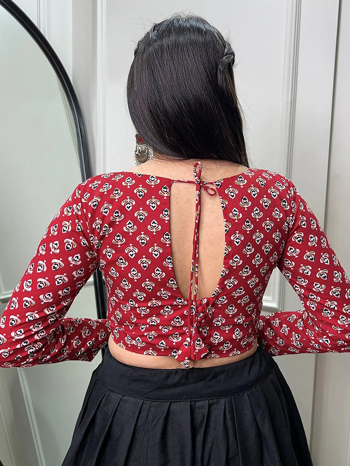 Red printed ethnic crop top with back tie detail, paired with black skirt for Indian wear