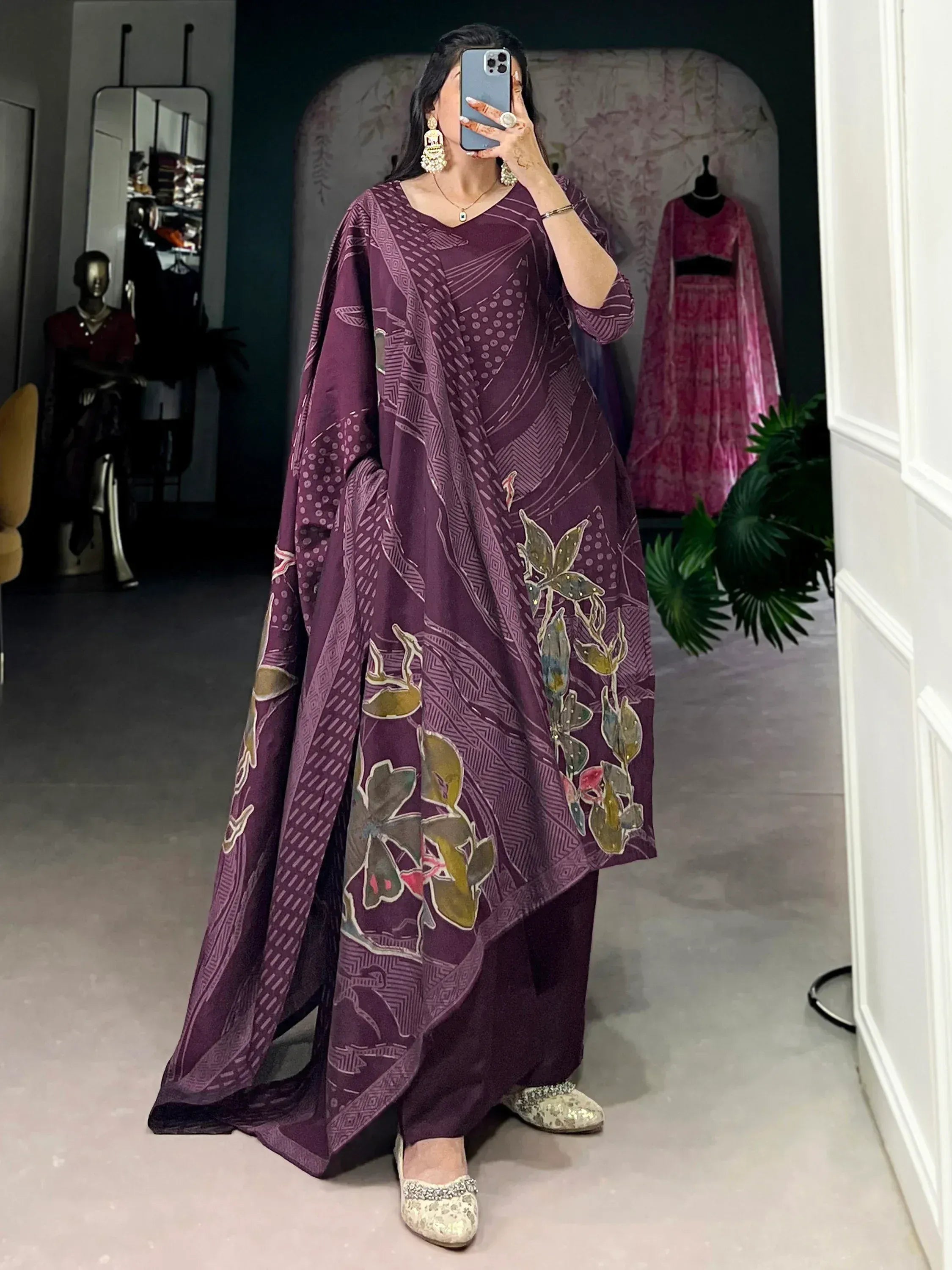 Purple printed ethnic gown with floral motifs, paired with palazzo pants and embellished flats for festive wear