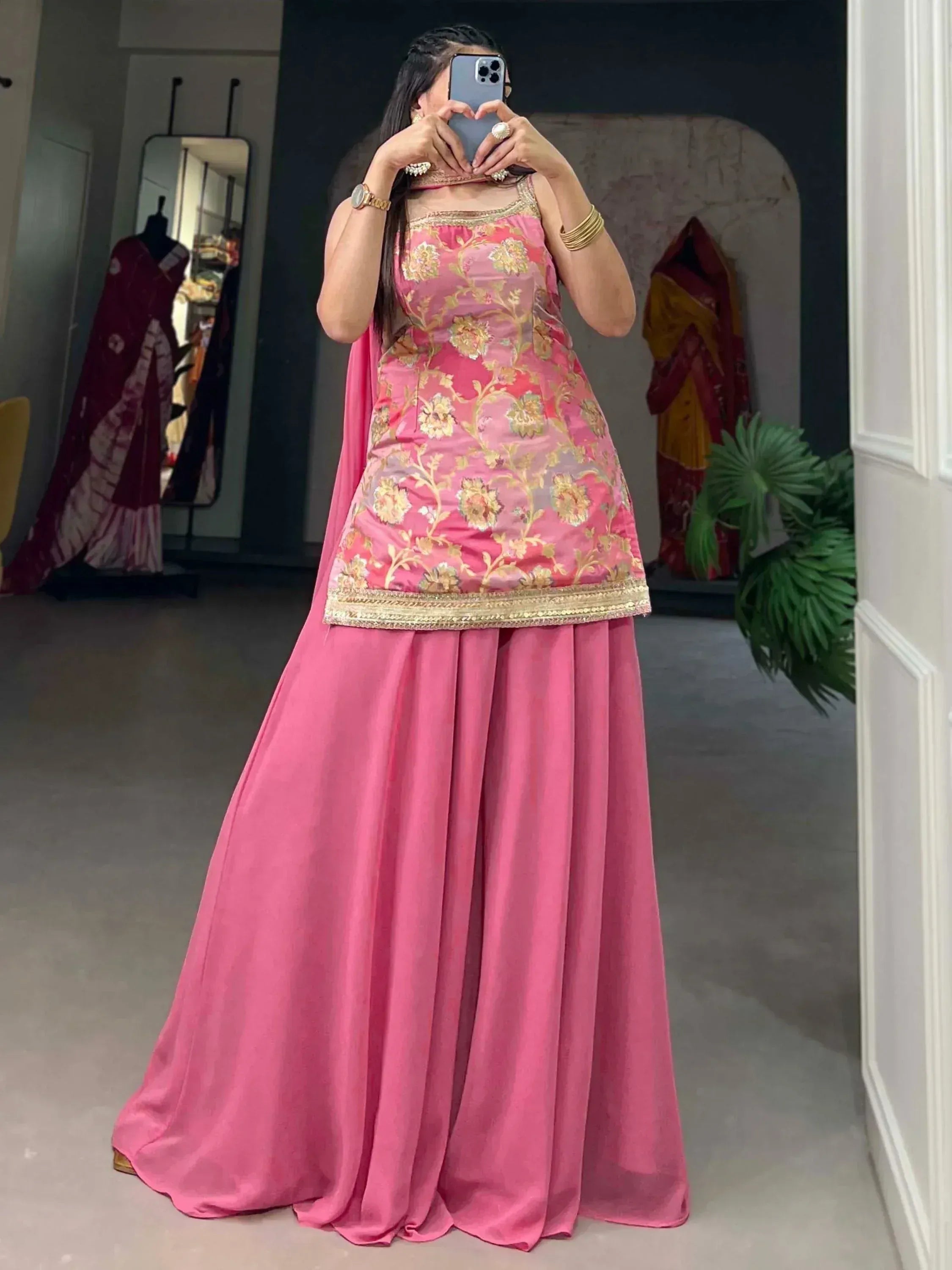 Pink floral embroidered ethnic gown with gold detailing, perfect for Indian weddings and festive occasions.