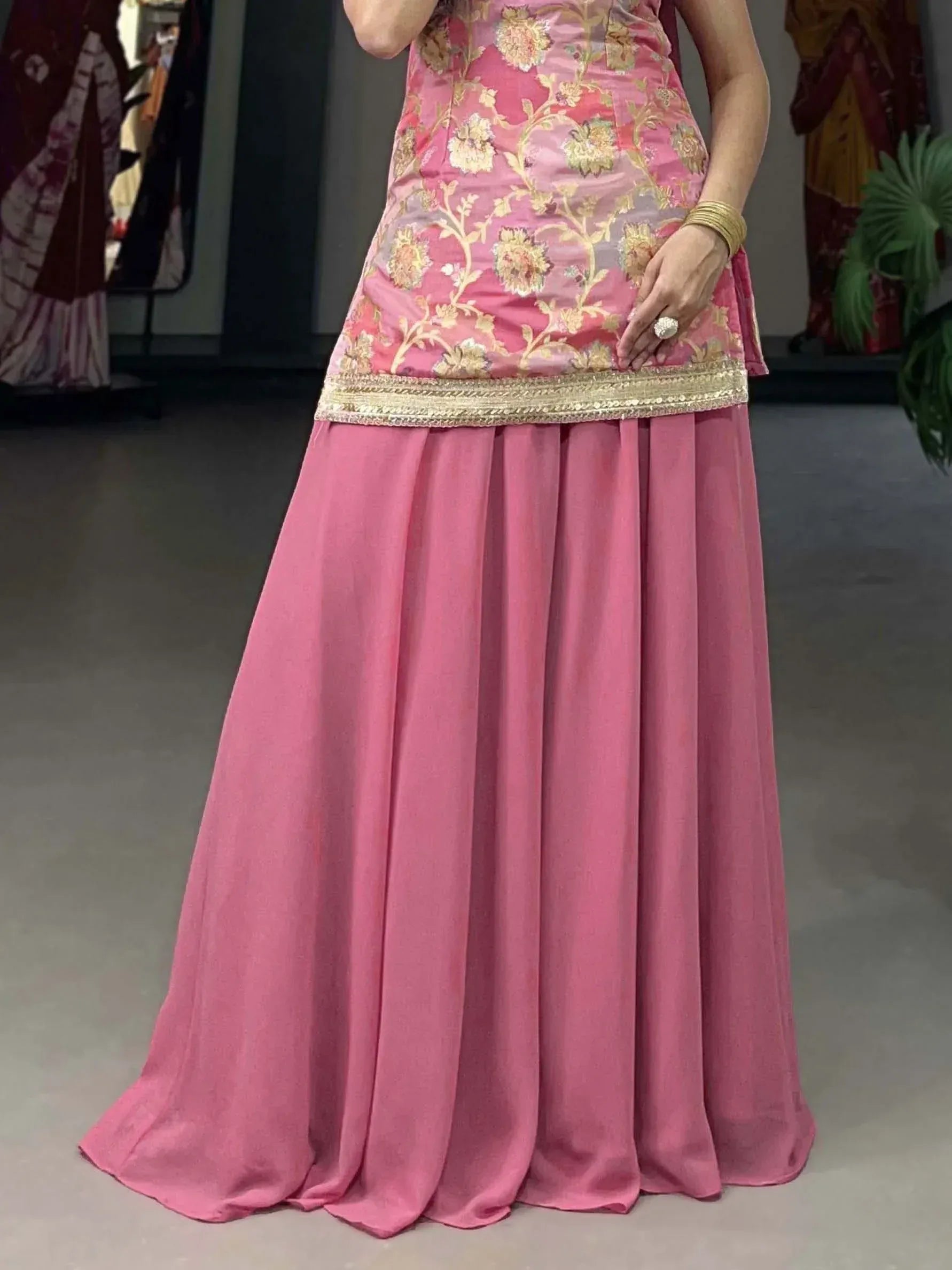 Pink floral embroidered ethnic gown with gold border, perfect for Indian celebrations and events.