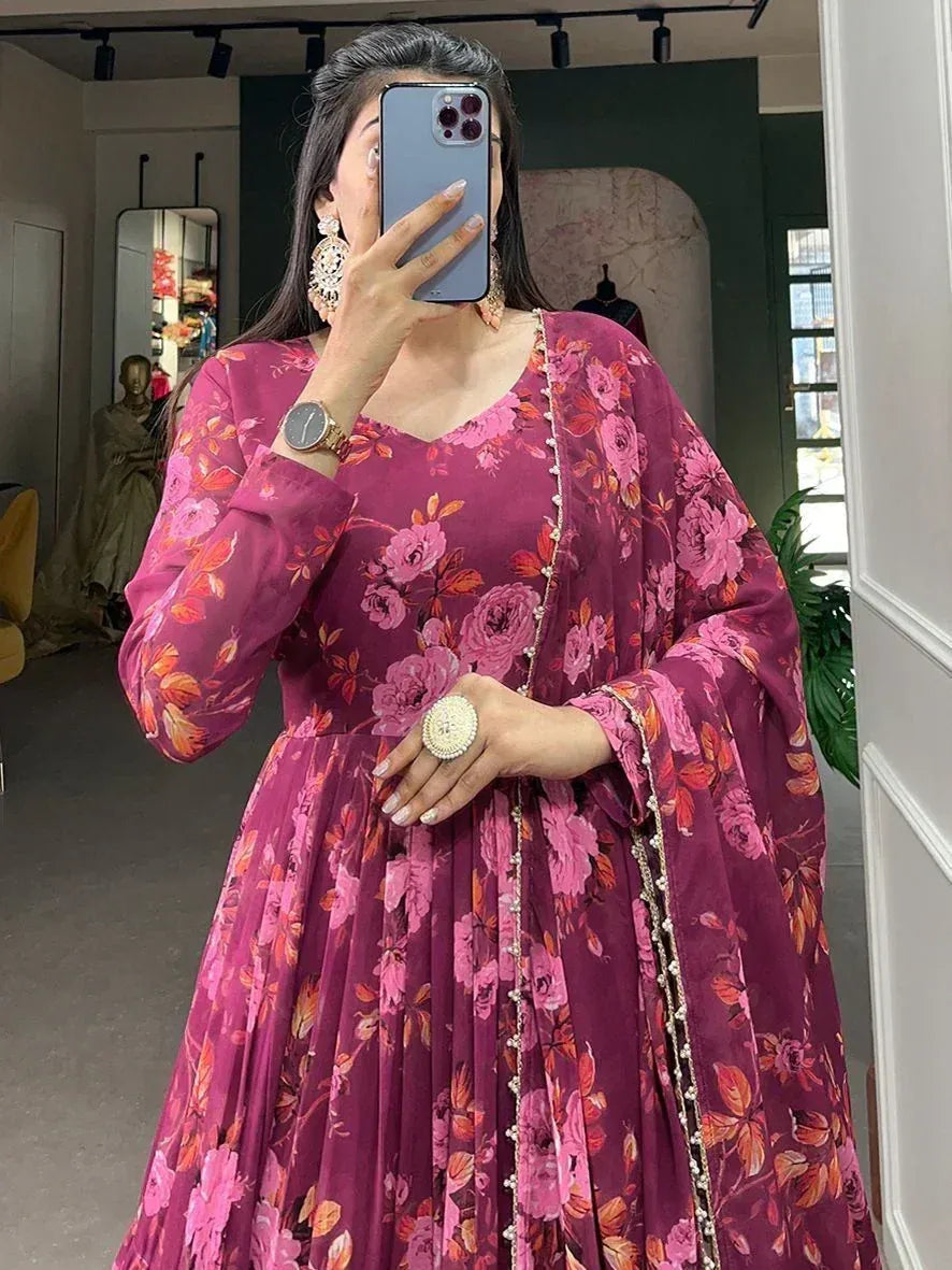 Woman in pink floral ethnic gown with pearl trim, taking mirror selfie in boutique