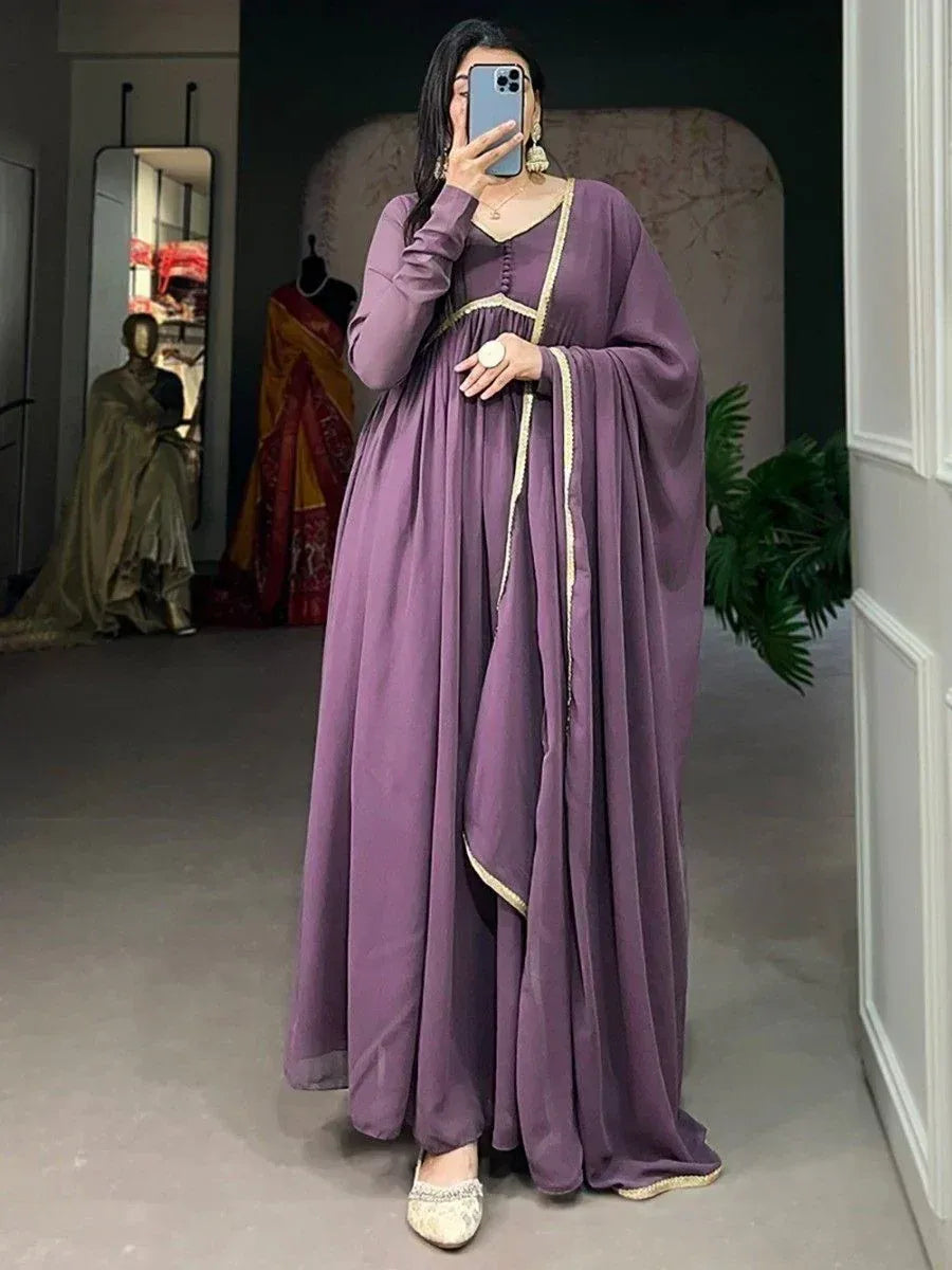 Purple ethnic gown with gold trim, long sleeves, and flared skirt, styled with embellished flats for festive occasions