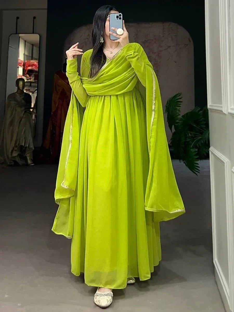 Vibrant lime green ethnic gown with draped velvet sleeves and gold trim, perfect for festive occasions.