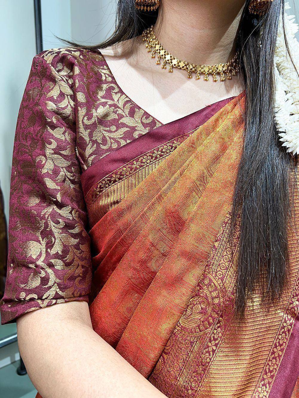 Elegant maroon and gold saree with intricate floral patterns and traditional jewelry