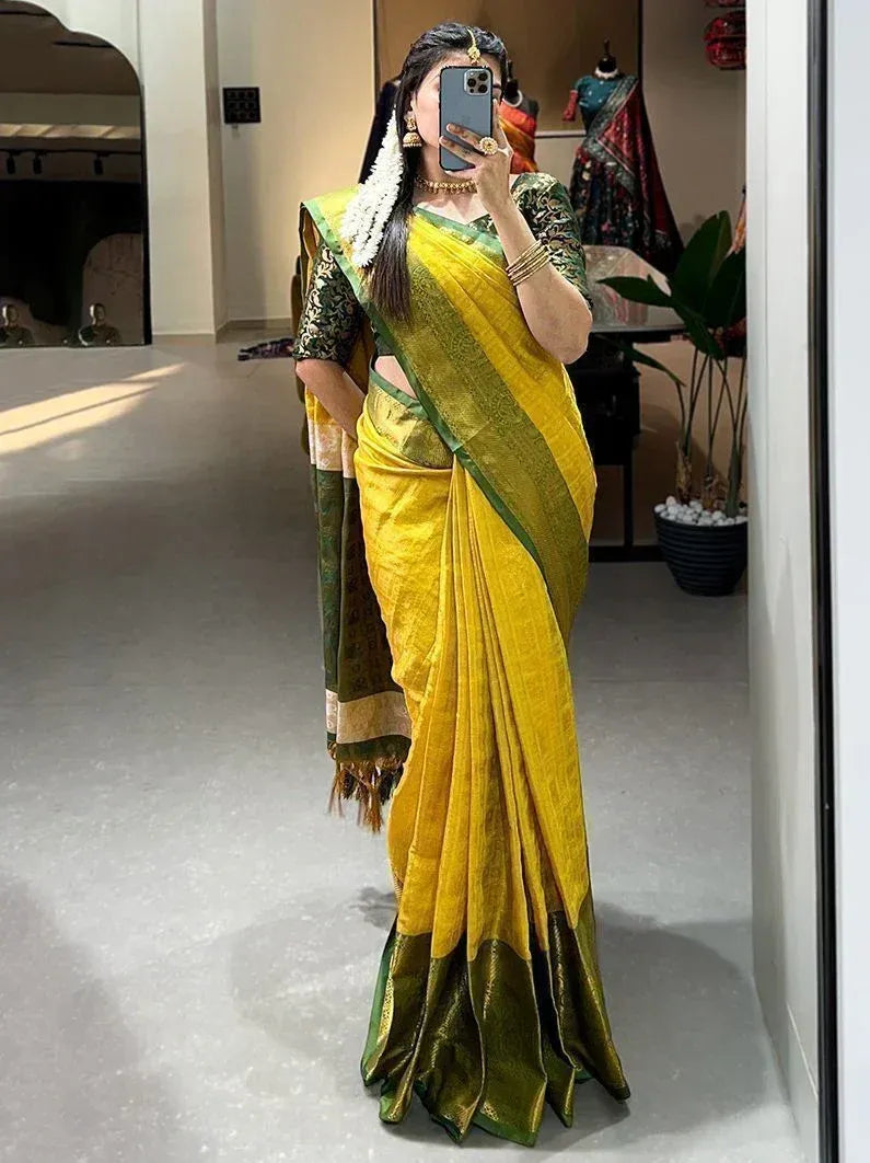 Woman in vibrant yellow and green ethnic saree with gold border, traditional Indian wear