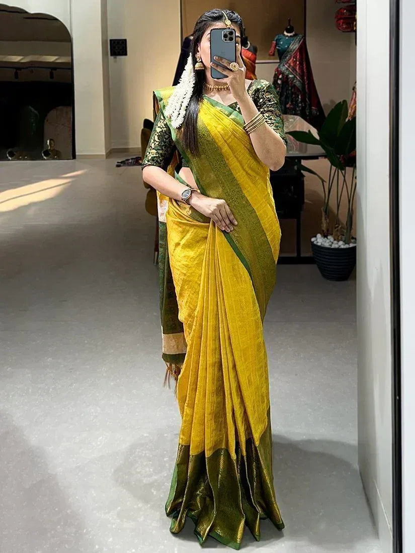Woman in vibrant yellow and green ethnic saree with floral blouse, traditional jewelry, taking mirror selfie