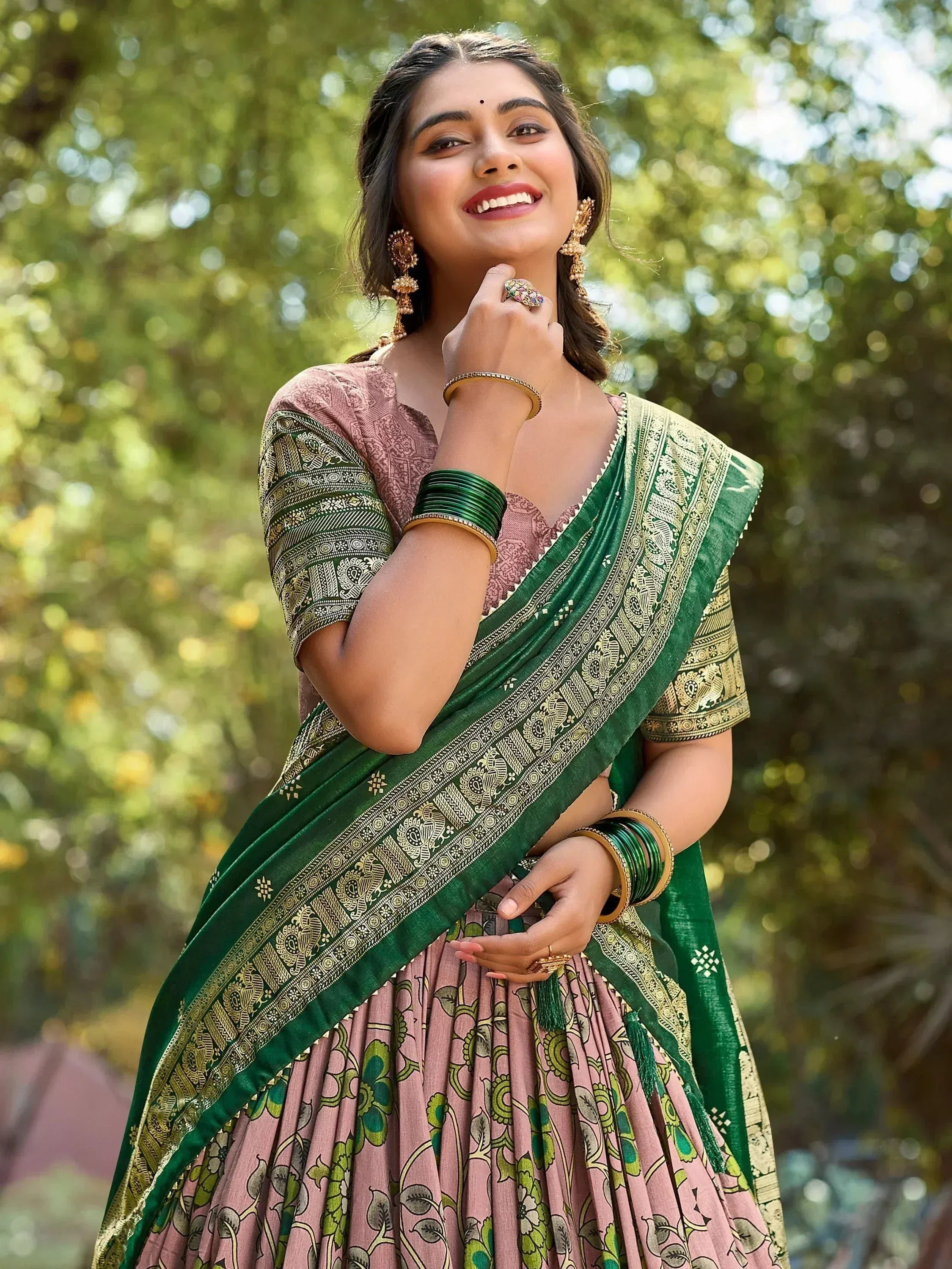 Woman in green and pink ethnic saree with gold embroidery, traditional Indian wear for festive occasions