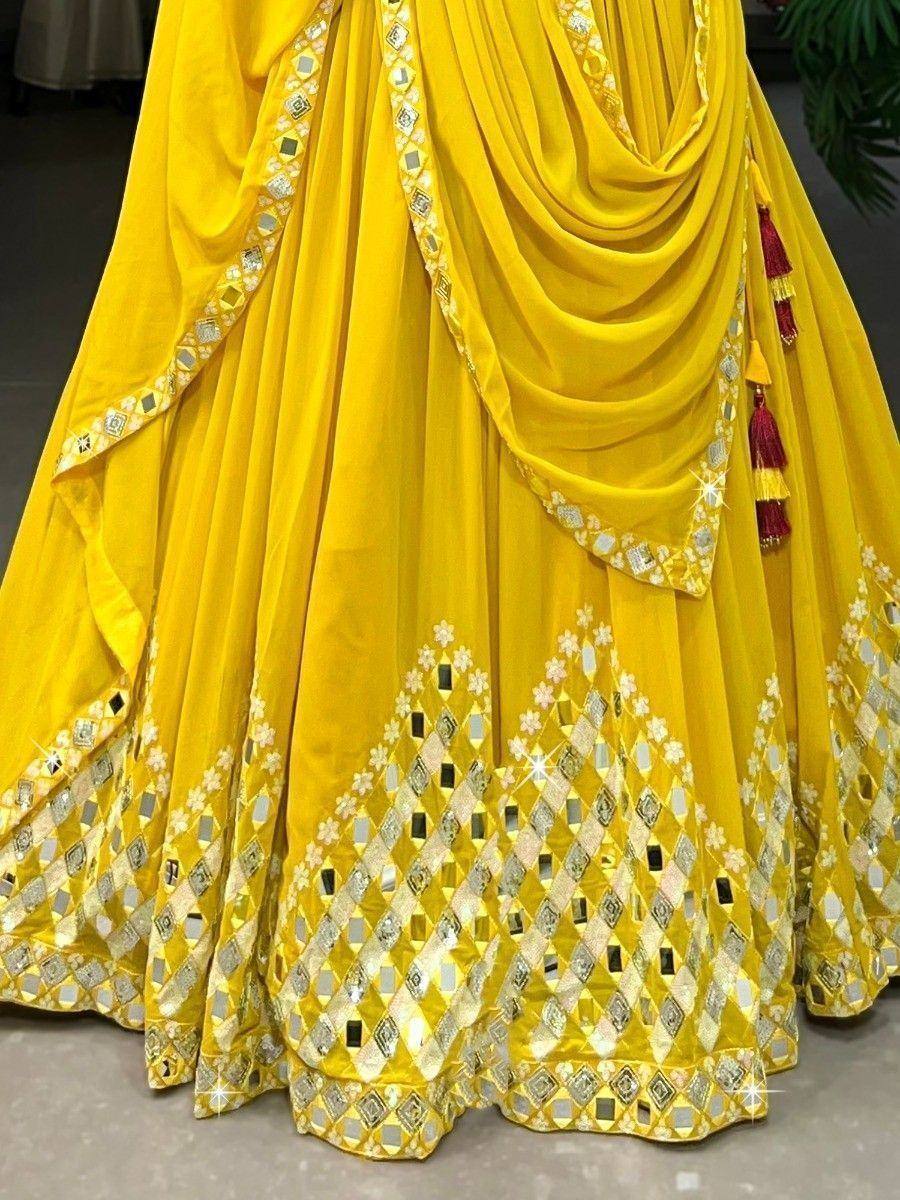 Vibrant yellow lehenga choli with mirror work and floral embroidery, perfect for Indian ethnic wear occasions.