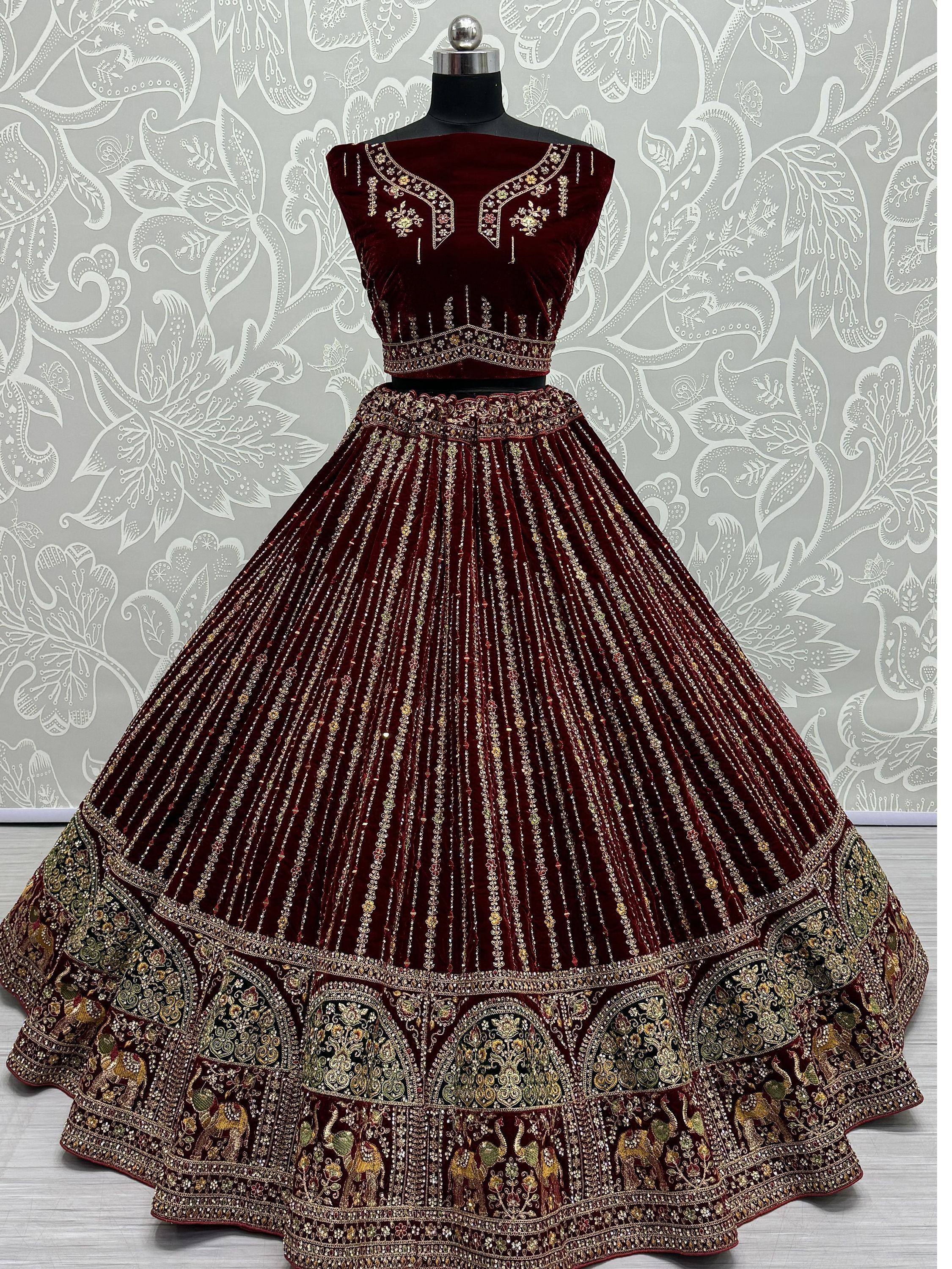 Maroon velvet lehenga choli with gold embroidery and elephant motifs, ideal for Indian weddings and festive occasions.