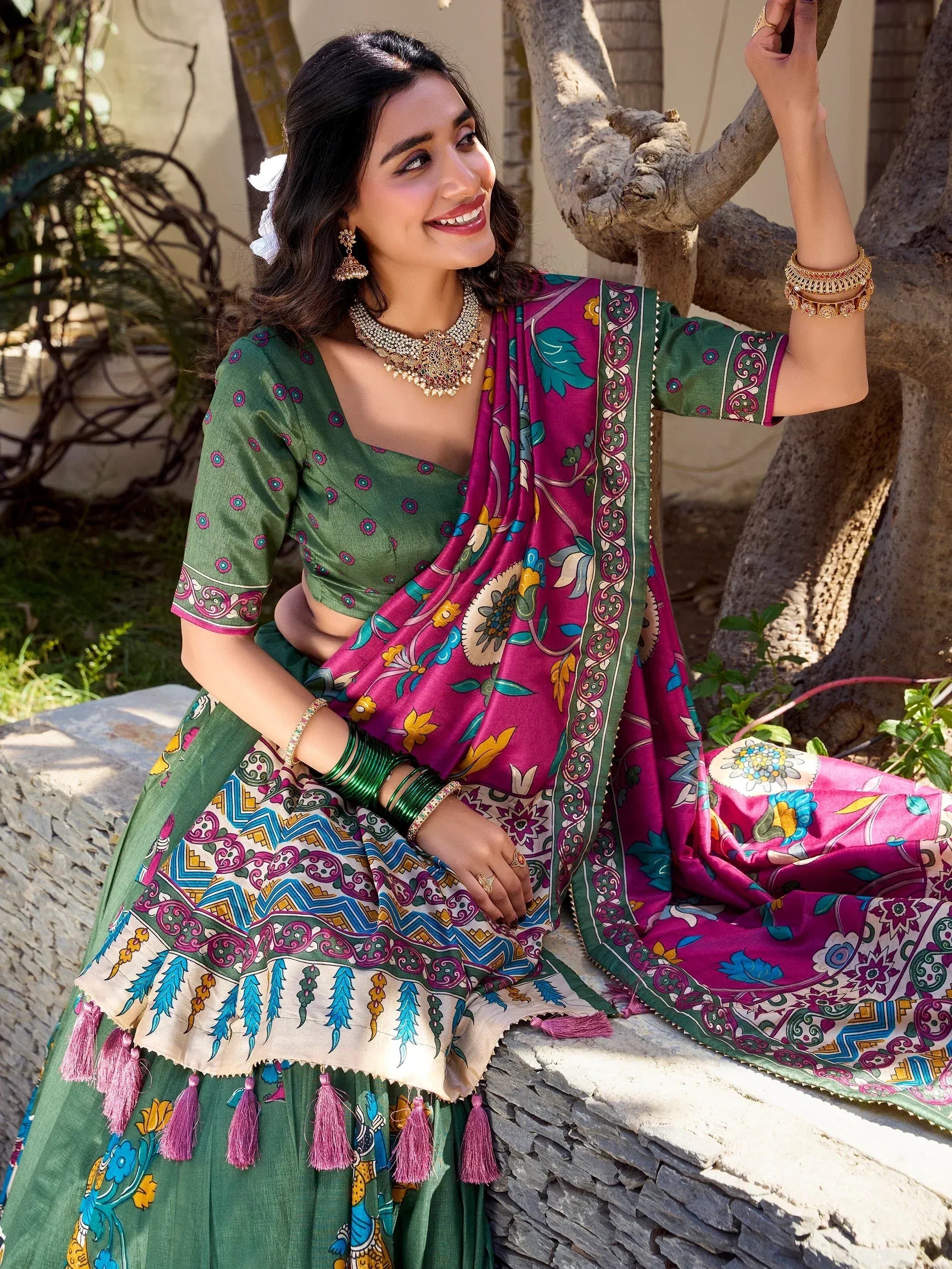 Woman in green and pink printed lehenga choli with floral dupatta, traditional Indian ethnic wear