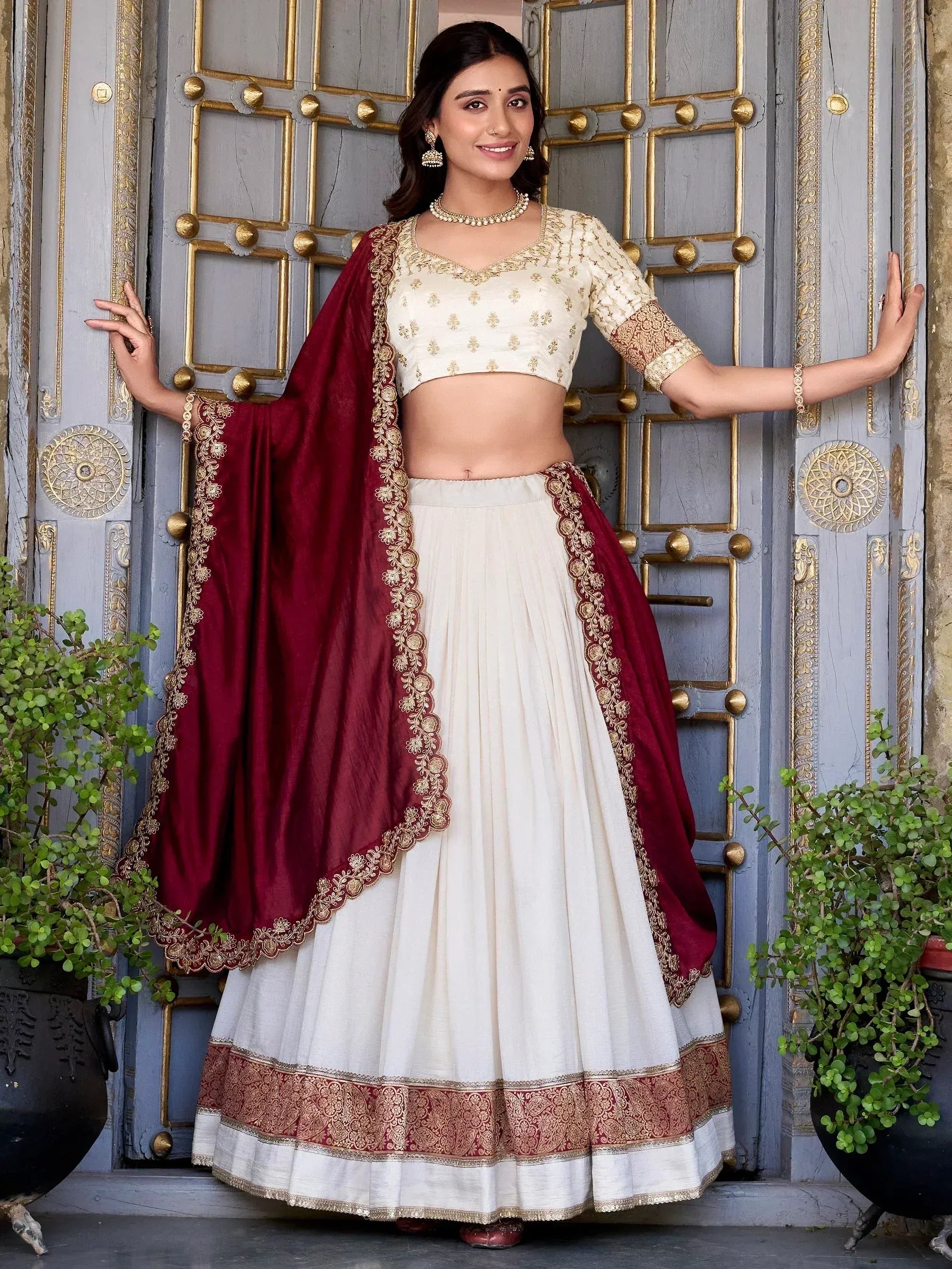 Elegant ivory lehenga choli with maroon dupatta, gold embroidery, perfect for Indian weddings or festive occasions
