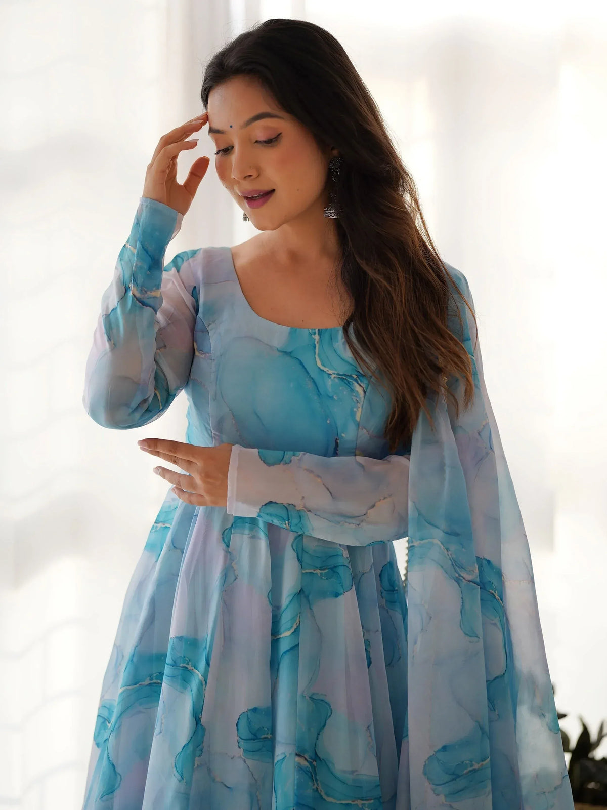 Woman in blue marble print ethnic gown with long sleeves, perfect for festive occasions and Indian wear.