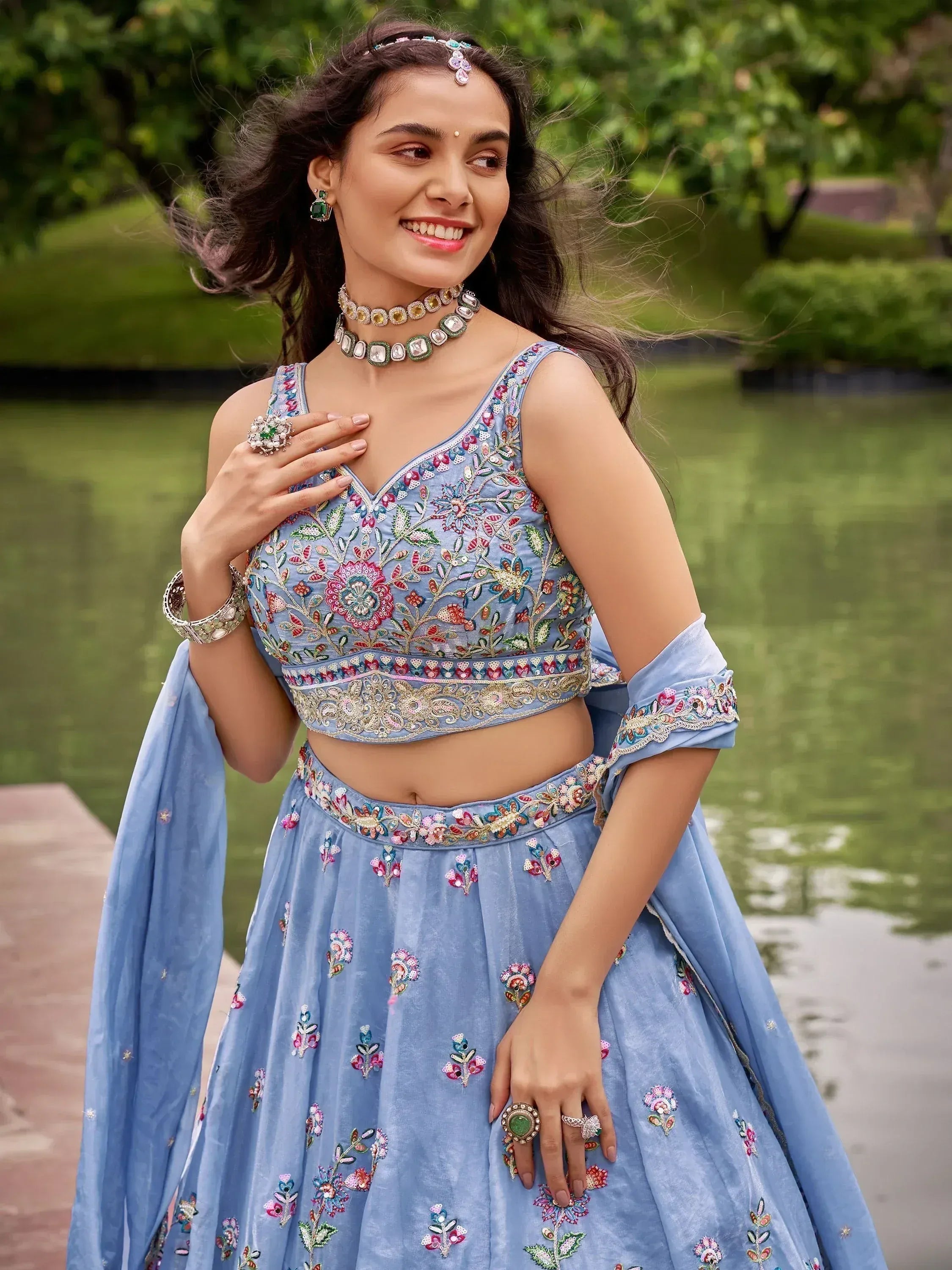 Blue floral embroidered lehenga choli with matching jewelry, perfect for Indian ethnic wear