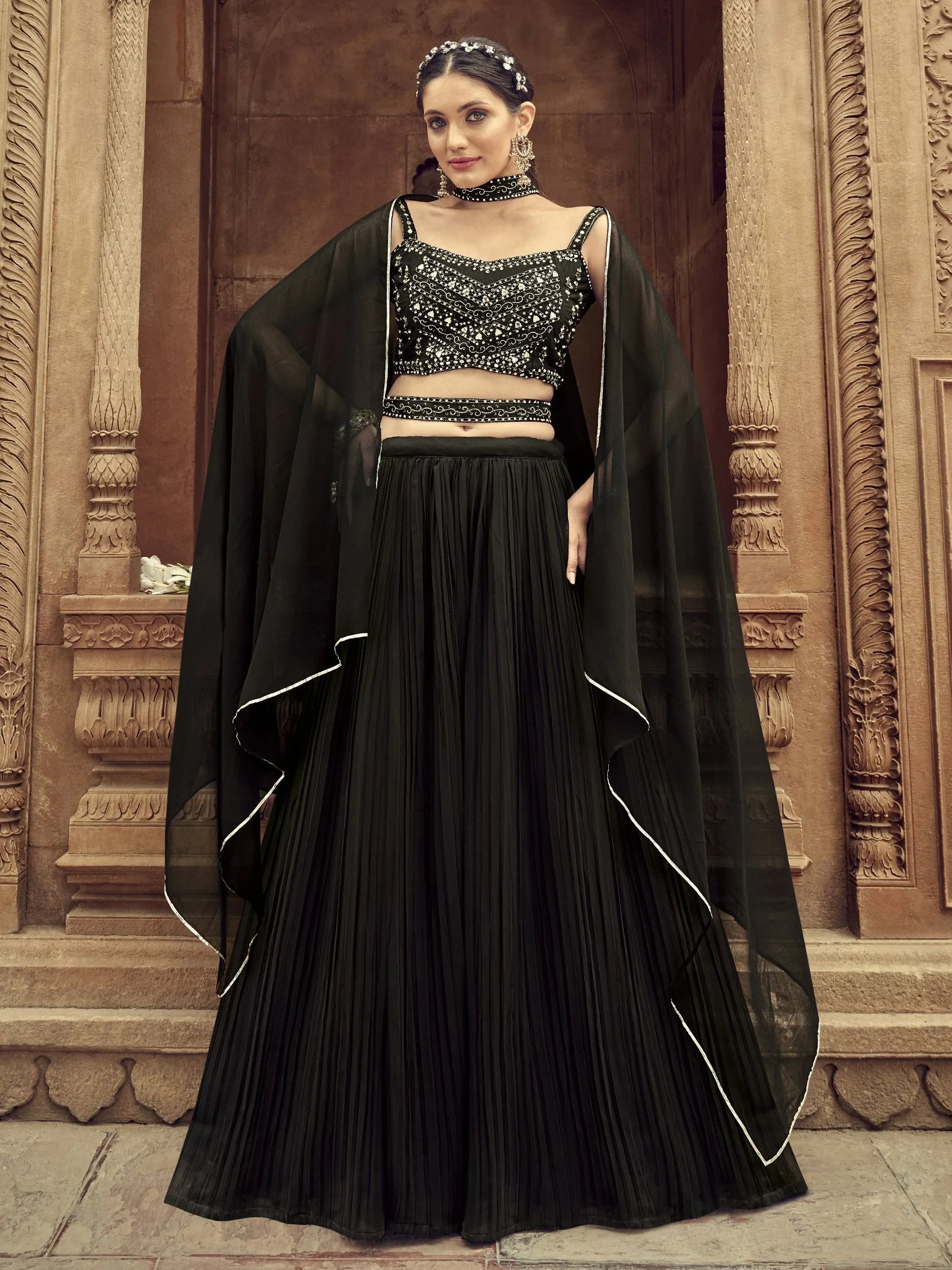 Black embroidered lehenga choli with pleated skirt and sheer cape, perfect for Indian ethnic wear events