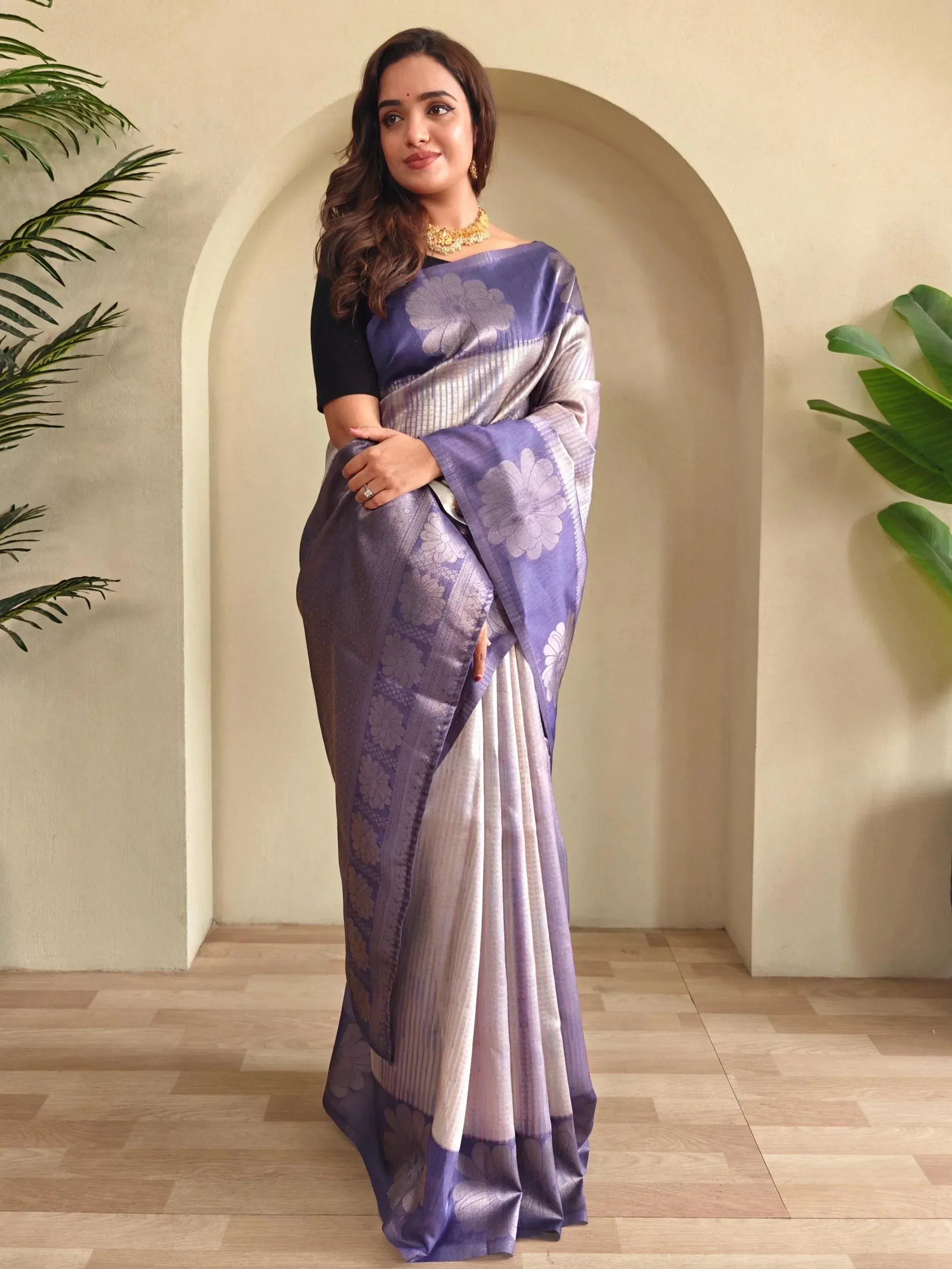 Woman in elegant purple and silver floral saree with black blouse, perfect for Indian ethnic occasions.