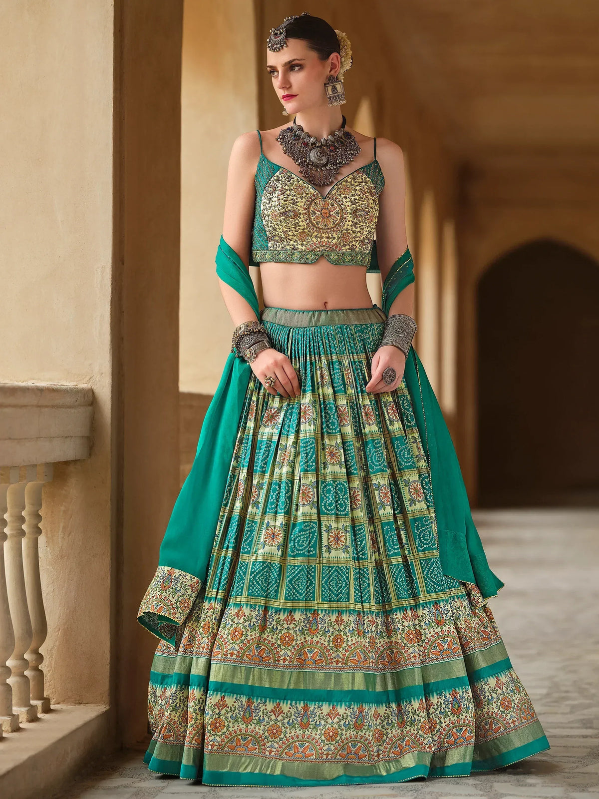 Teal and gold embroidered lehenga choli with intricate patterns, perfect for Indian ethnic wear occasions.