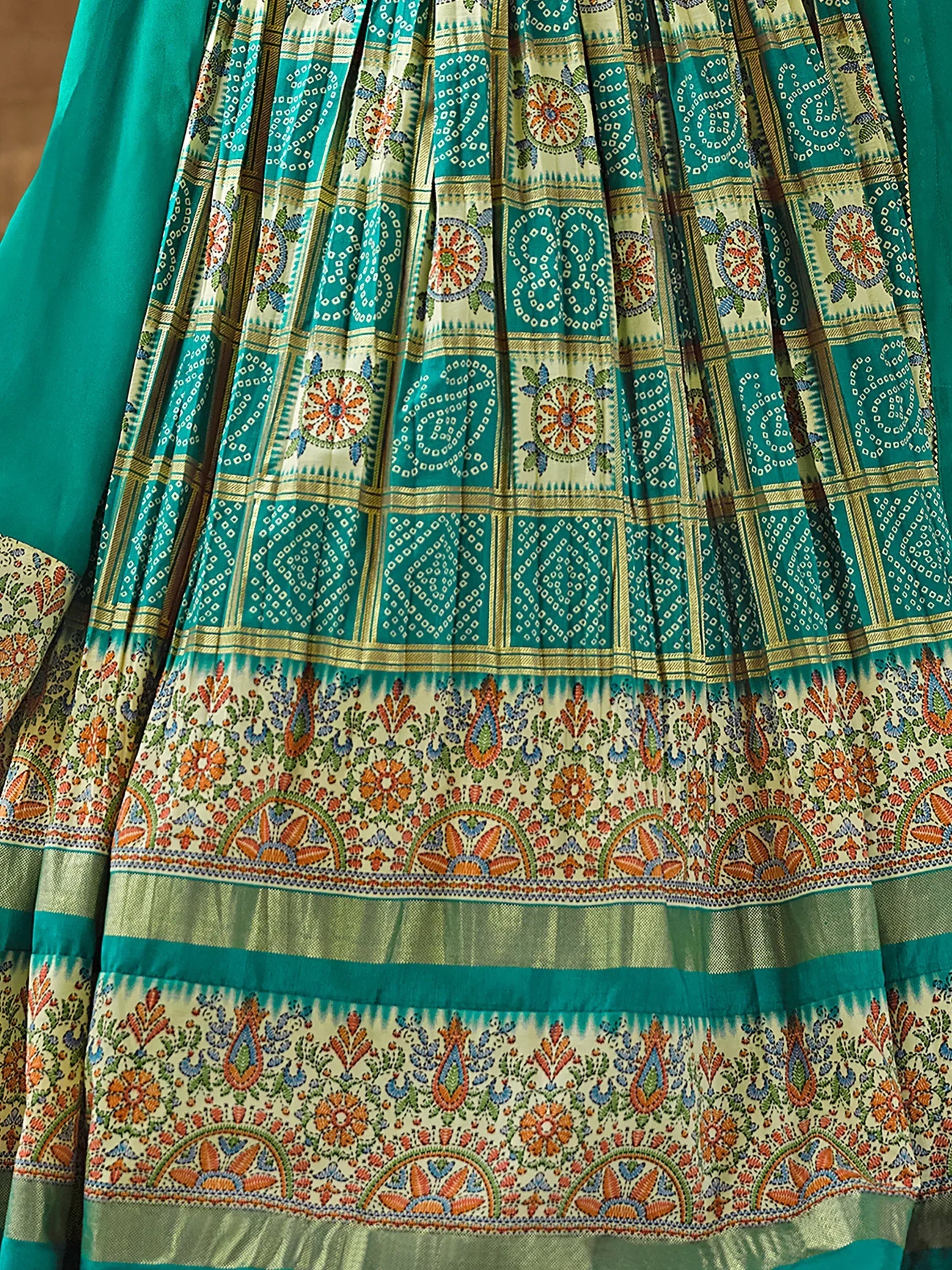 Teal and cream printed ethnic gown with intricate floral and geometric patterns, perfect for Indian occasions.