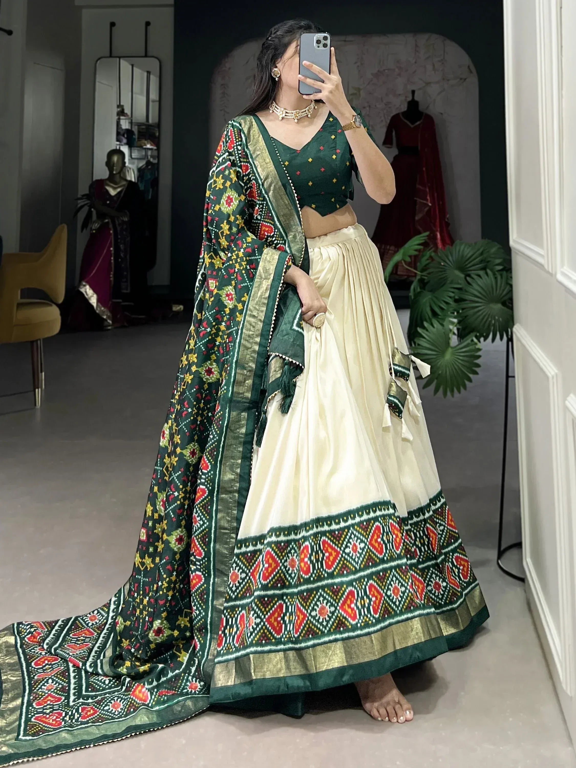 Green and cream ethnic lehenga choli with vibrant geometric print and gold border, perfect for festive occasions.