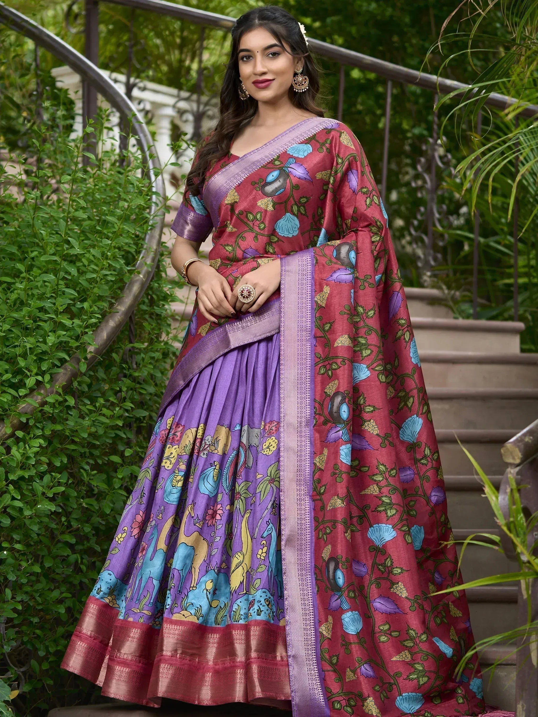 Woman in vibrant purple and pink printed saree with floral and animal motifs, perfect for ethnic occasions.