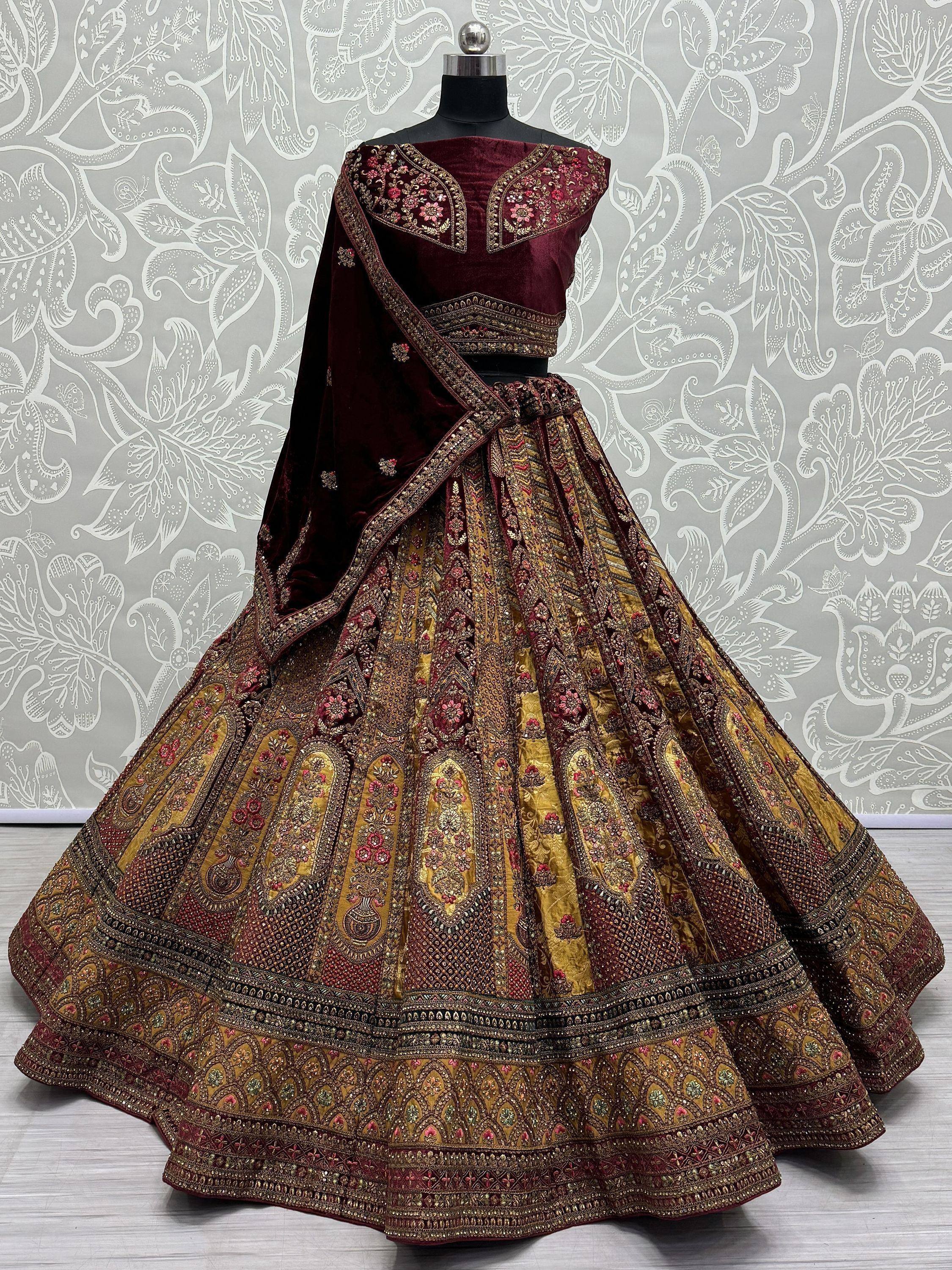 Maroon velvet designer lehenga choli with gold embroidery, perfect for weddings and festive occasions.
