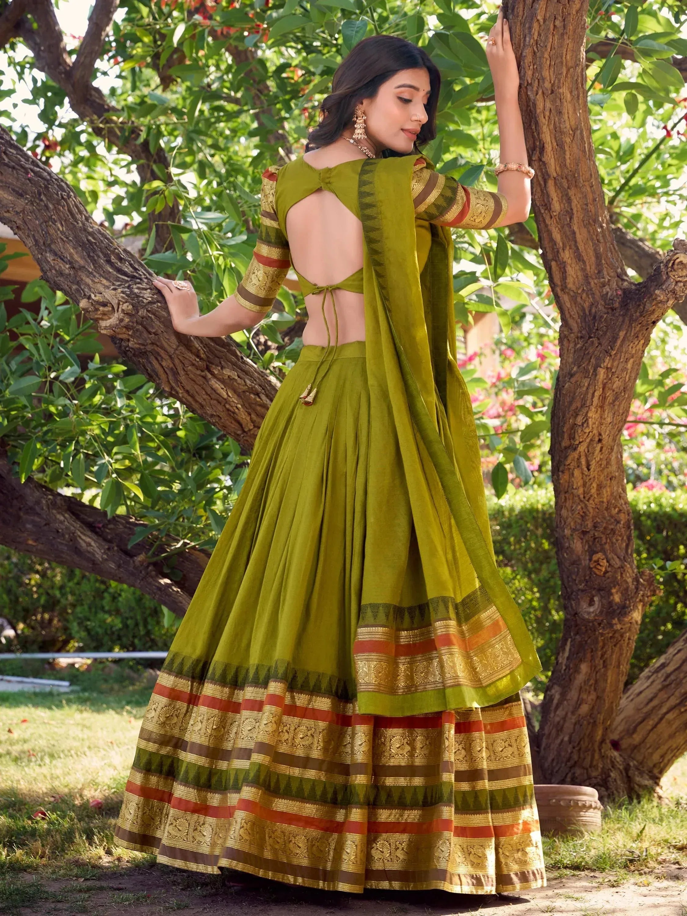 Olive green designer lehenga choli with gold border, backless blouse, and pleated skirt, perfect for ethnic occasions.