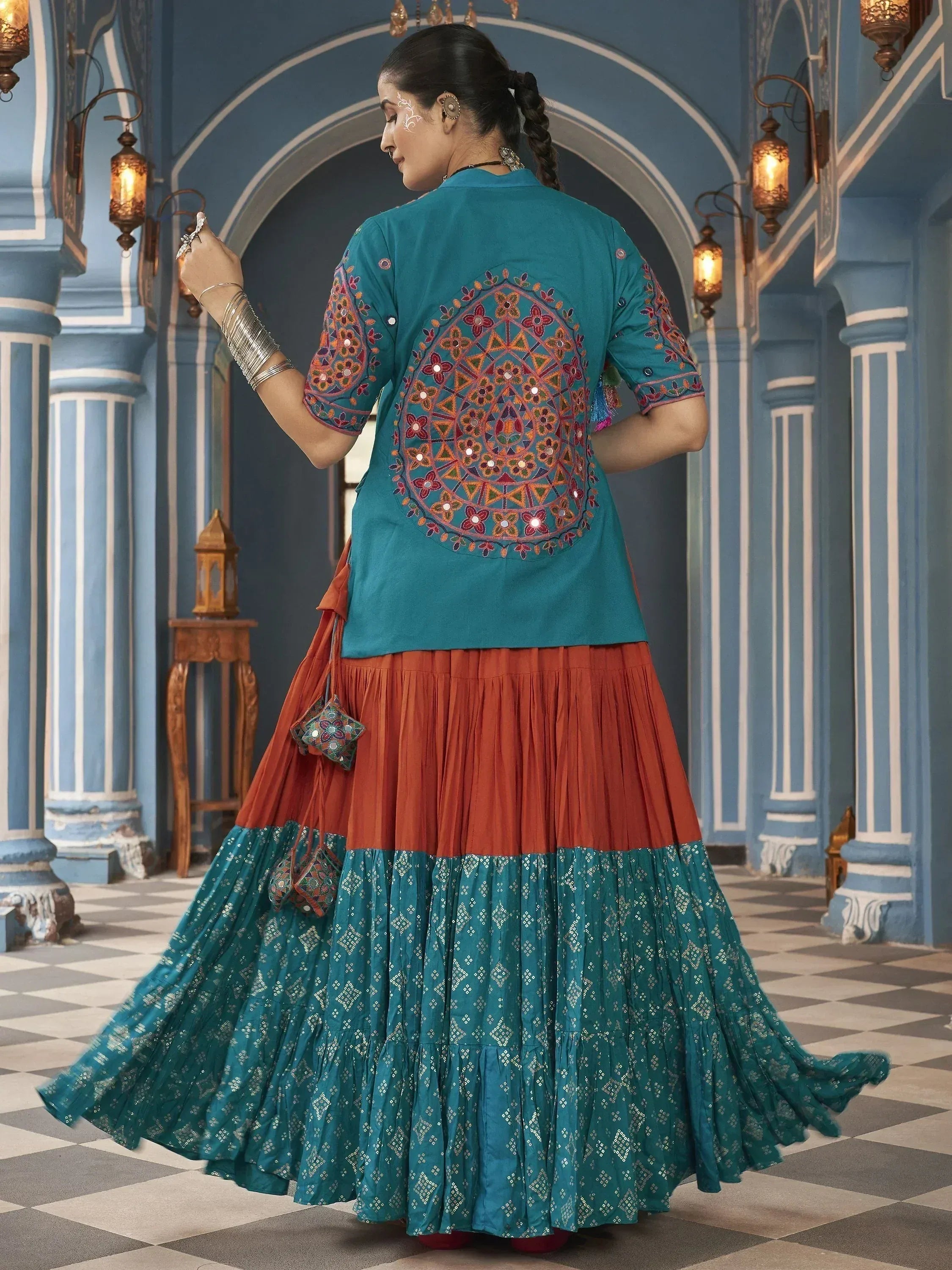 Teal embroidered top with orange and teal layered skirt, showcasing Indian ethnic wear design