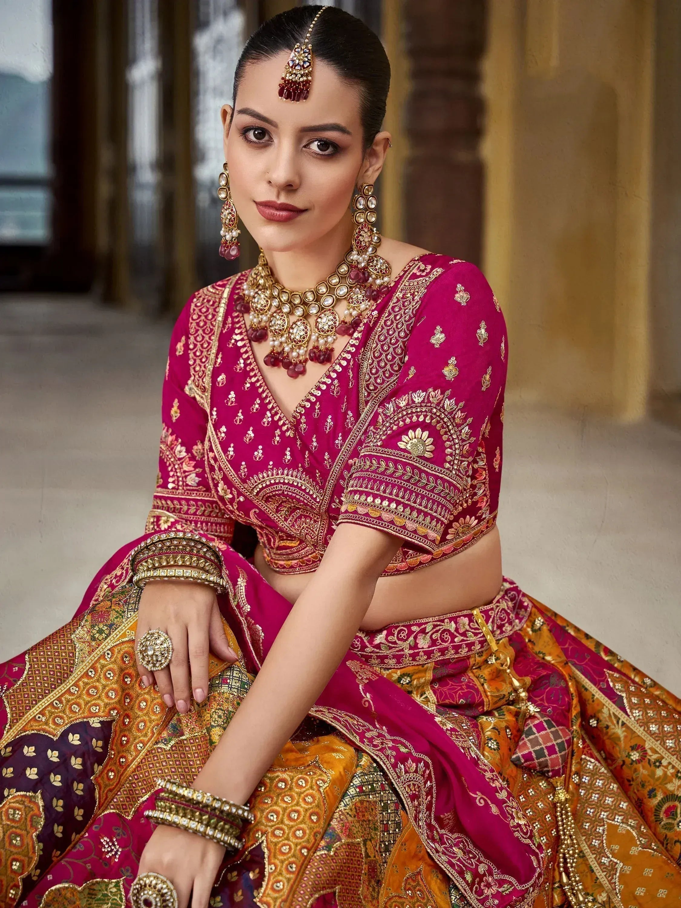 Elegant woman in pink and gold embroidered lehenga choli with traditional Indian jewelry