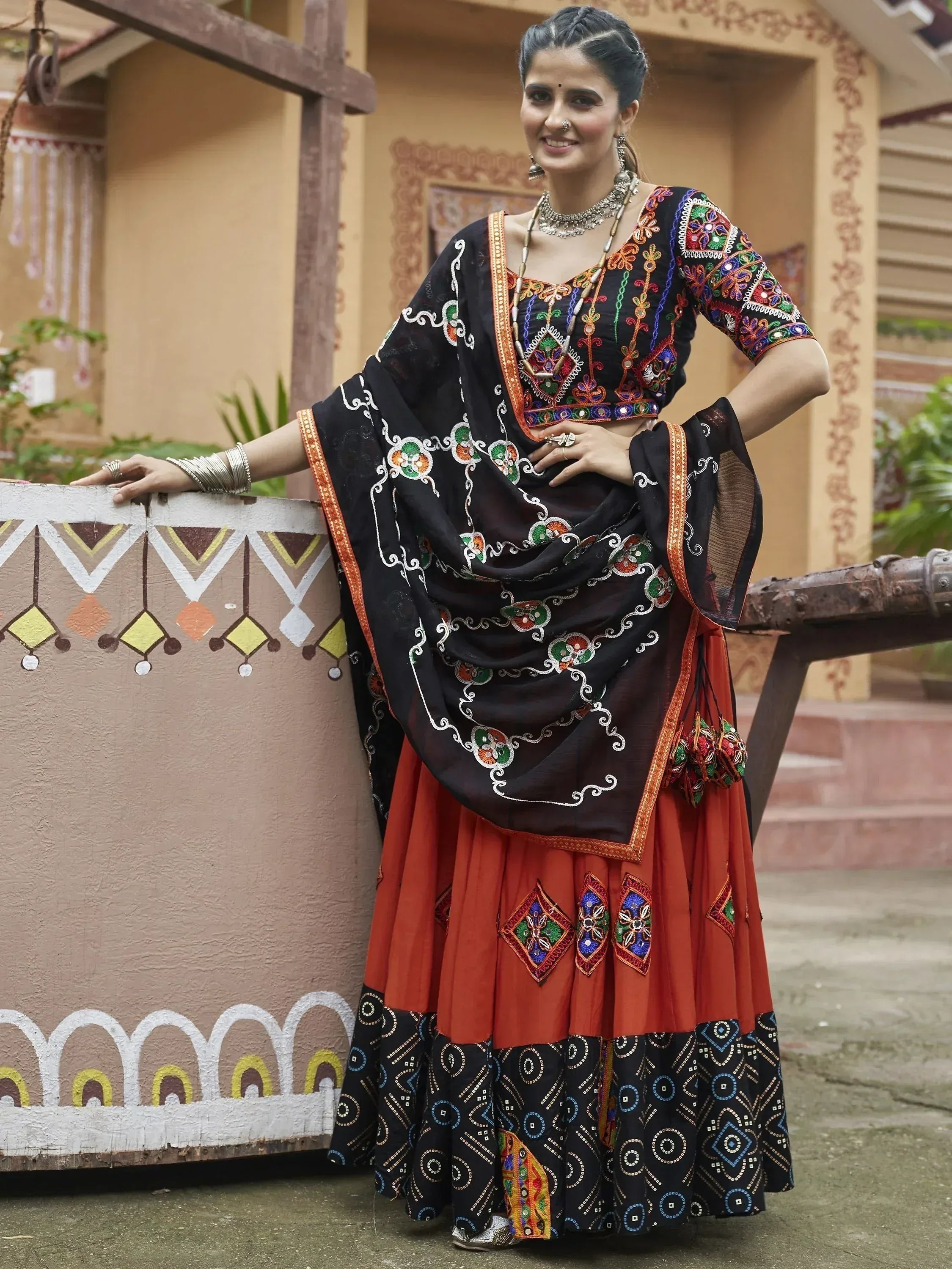 Black and rust ethnic lehenga choli with colorful embroidery, perfect for Indian festivals and weddings.