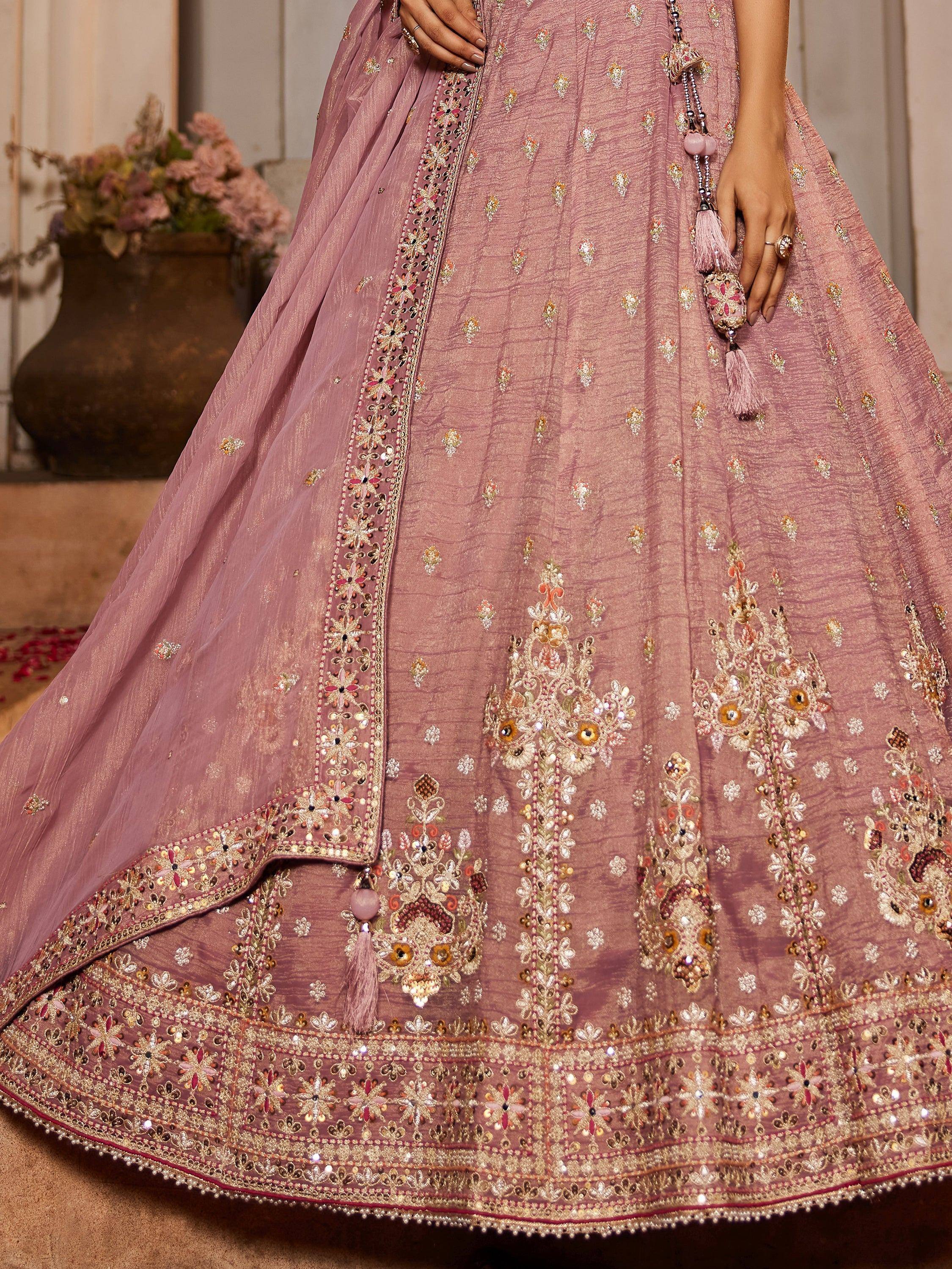 Dusty pink designer lehenga choli with intricate gold embroidery and floral motifs, perfect for weddings.