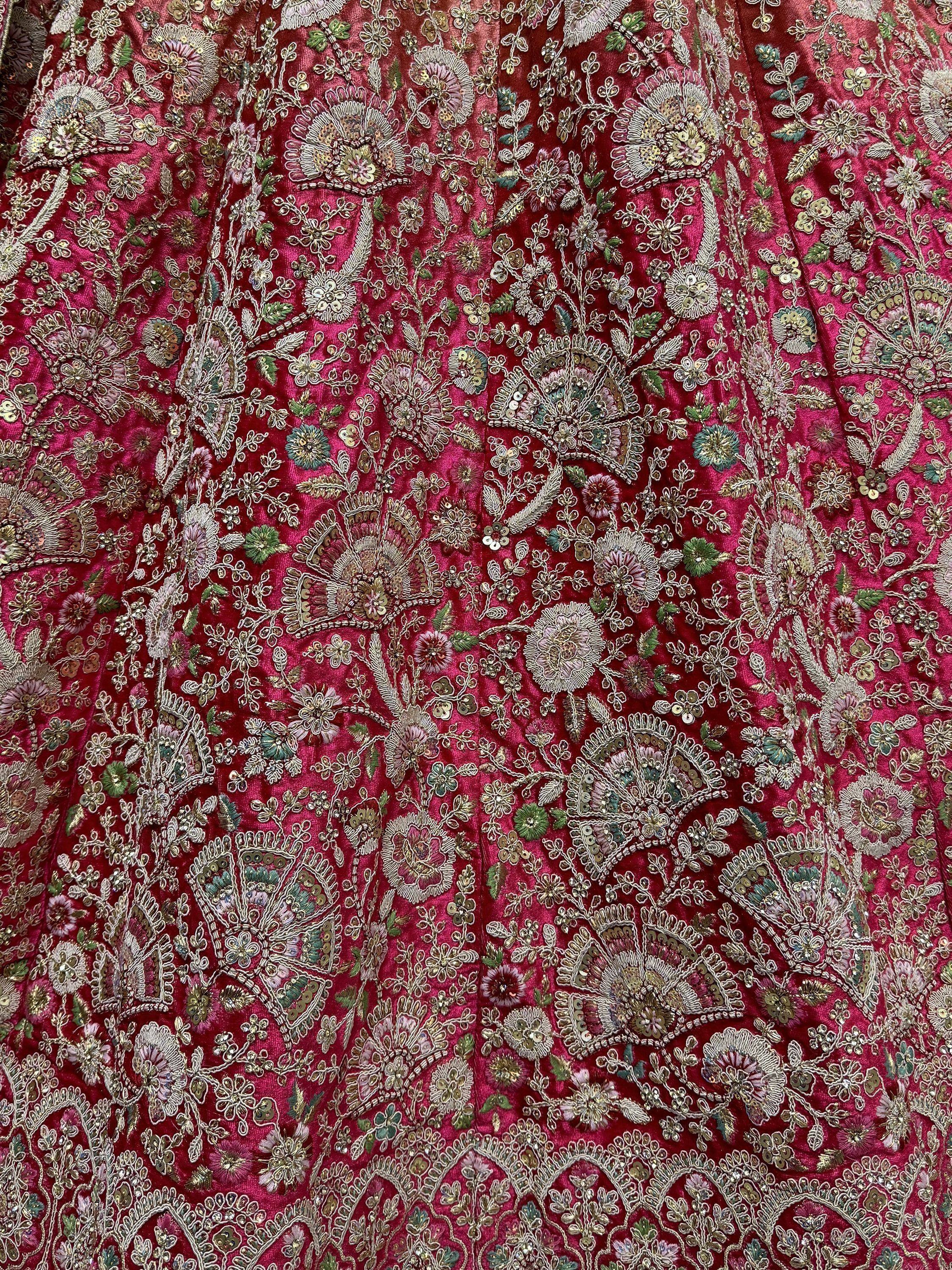 Rich red ethnic wear fabric with intricate floral embroidery and sequin detailing for designer lehenga or saree