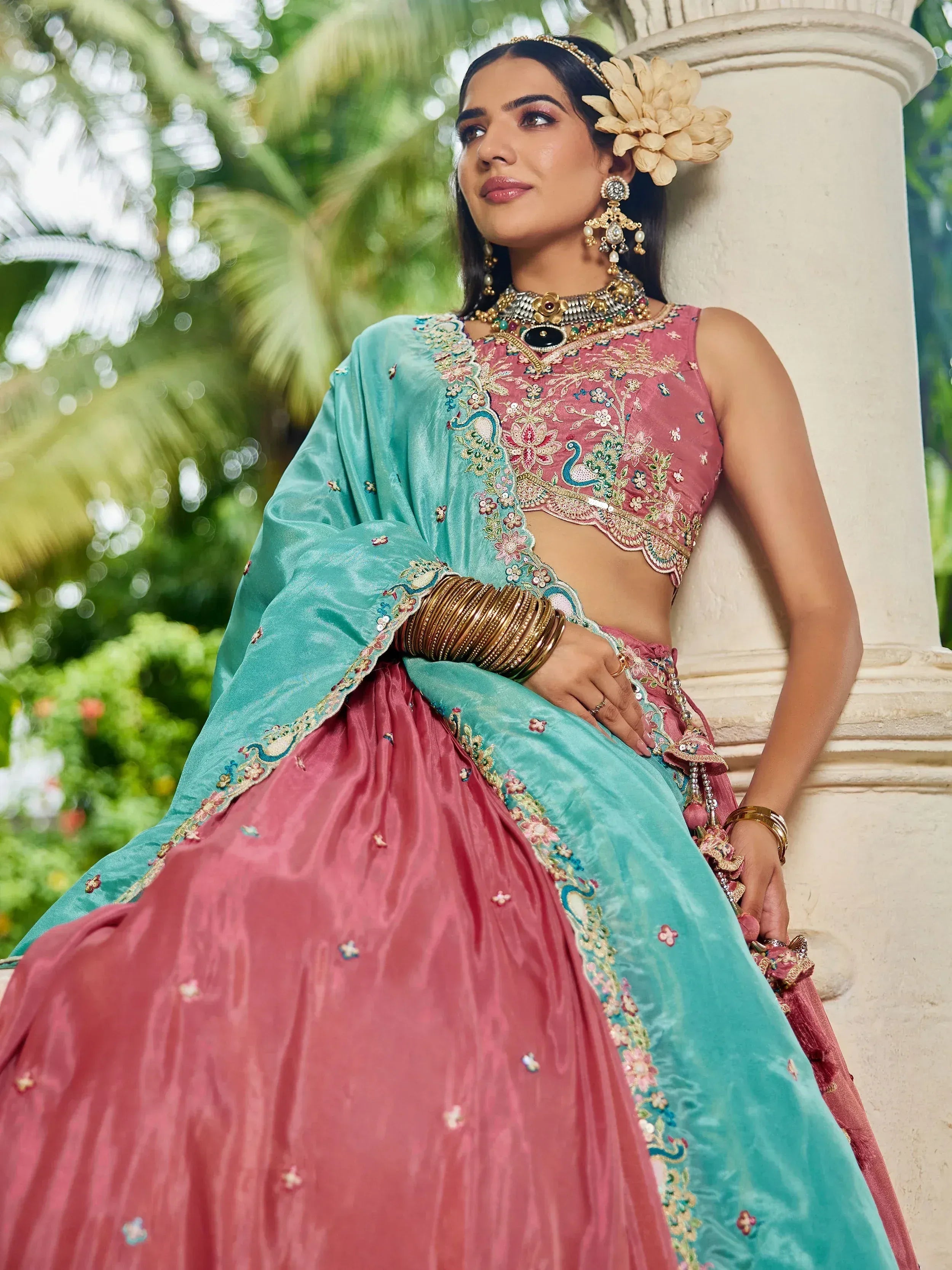 Pink and teal embroidered lehenga choli with peacock motifs, perfect for Indian weddings and festive occasions.