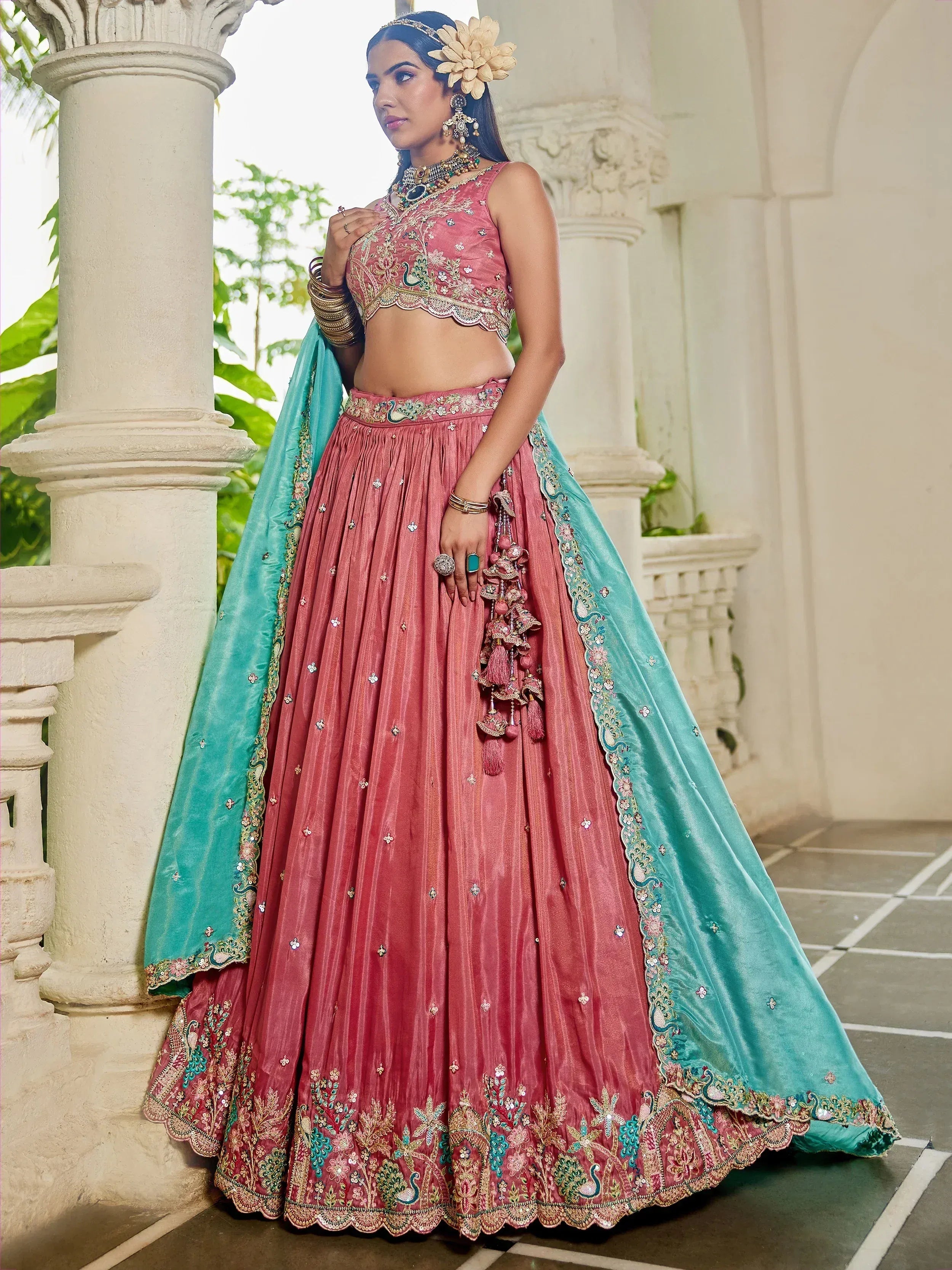 Pink and turquoise embroidered lehenga choli with peacock motifs, perfect for Indian weddings and festive occasions.