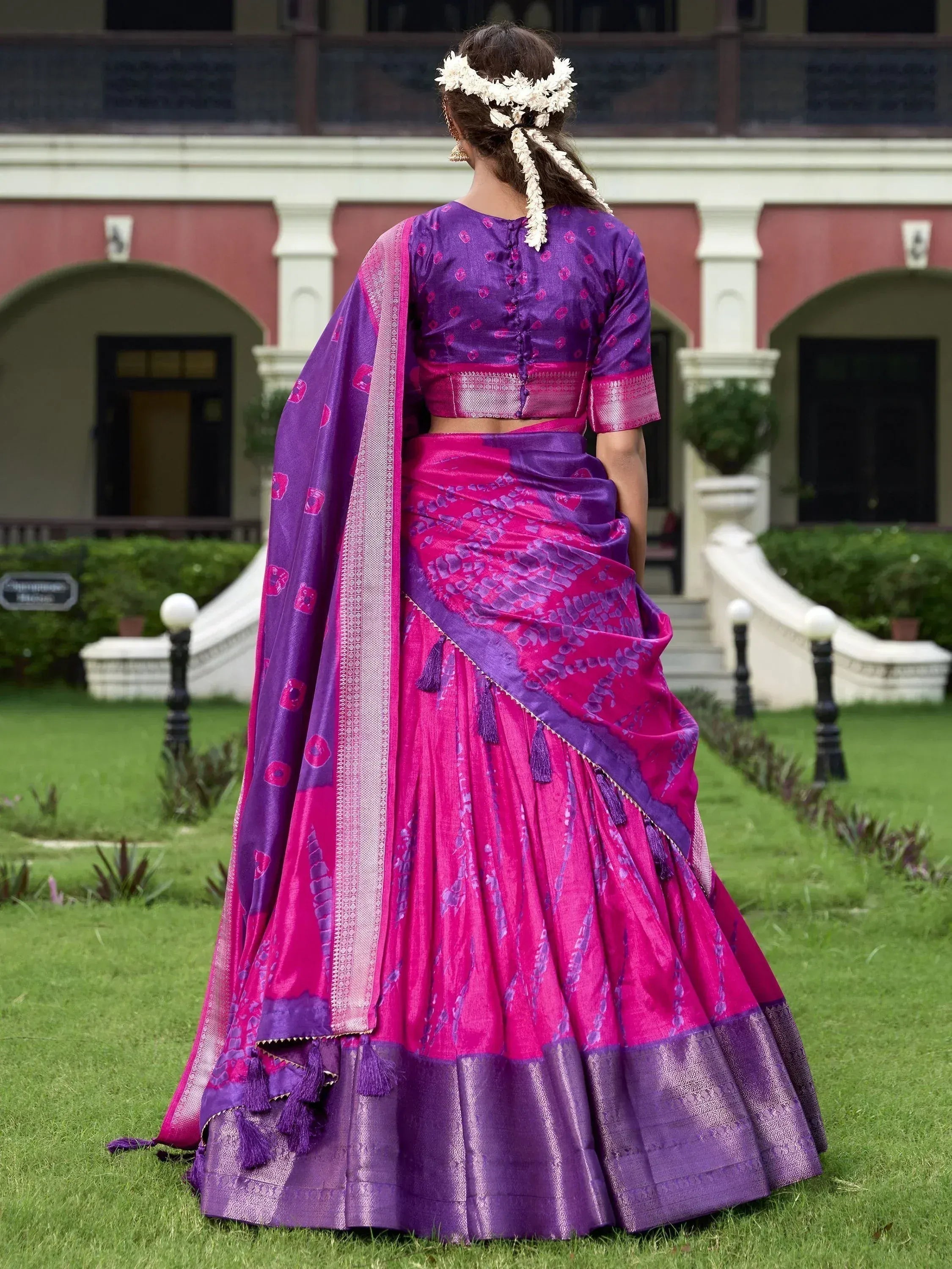 Purple and pink designer lehenga choli with floral hair accessory, perfect for Indian ethnic wear occasions.
