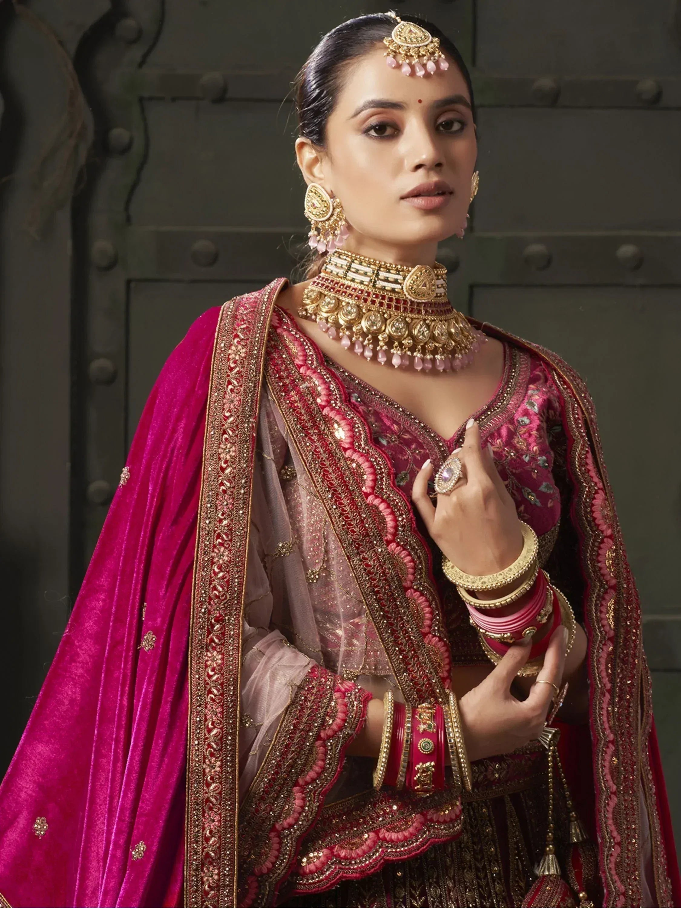 Elegant Indian ethnic wear with intricate embroidery, pink velvet dupatta, and traditional jewelry for weddings or festivals