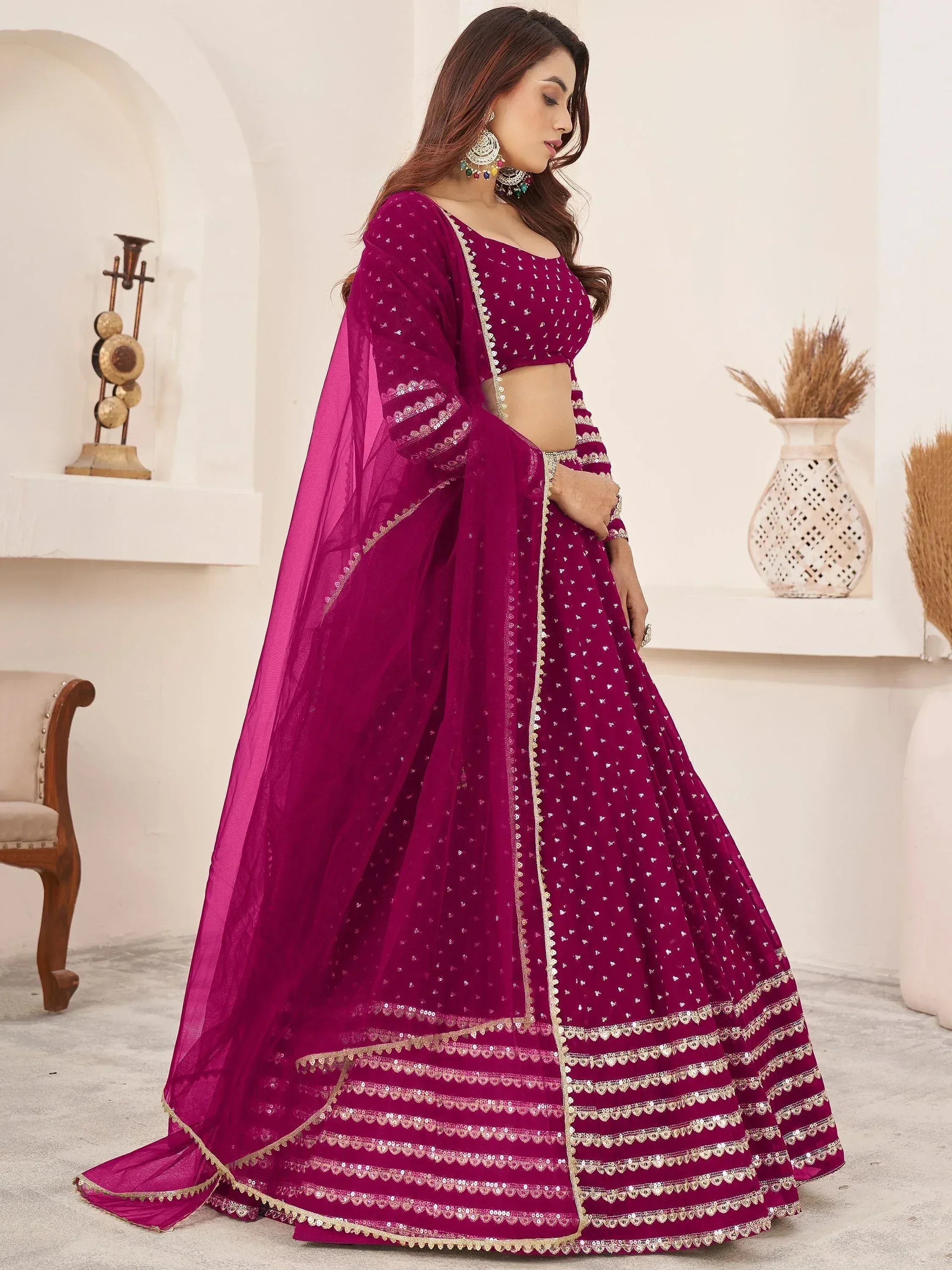 Elegant maroon lehenga choli with gold embroidery and sheer dupatta, perfect for Indian weddings and festive occasions.