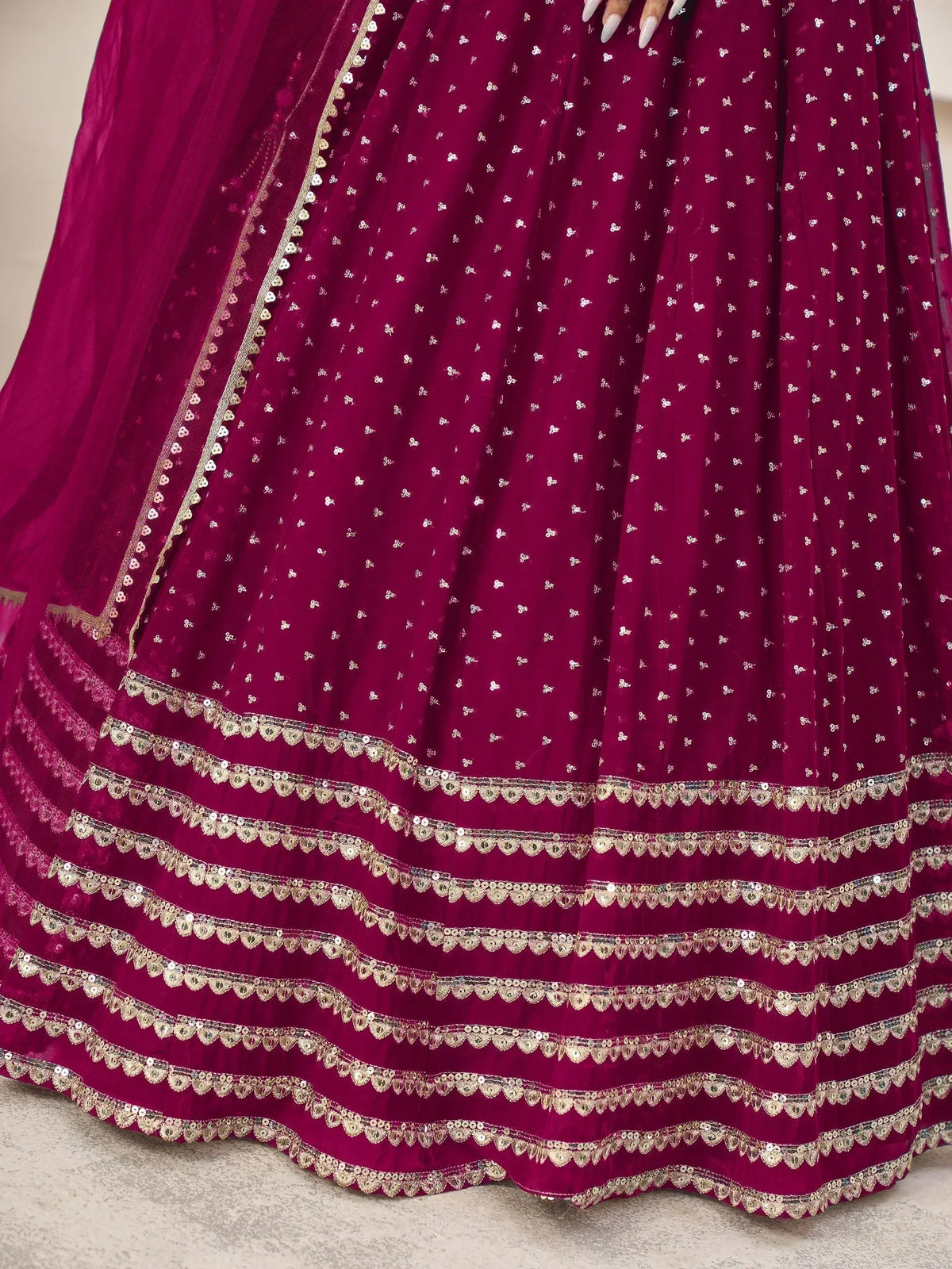 Rich maroon lehenga with gold sequin embroidery and scalloped borders, perfect for Indian ethnic wear.