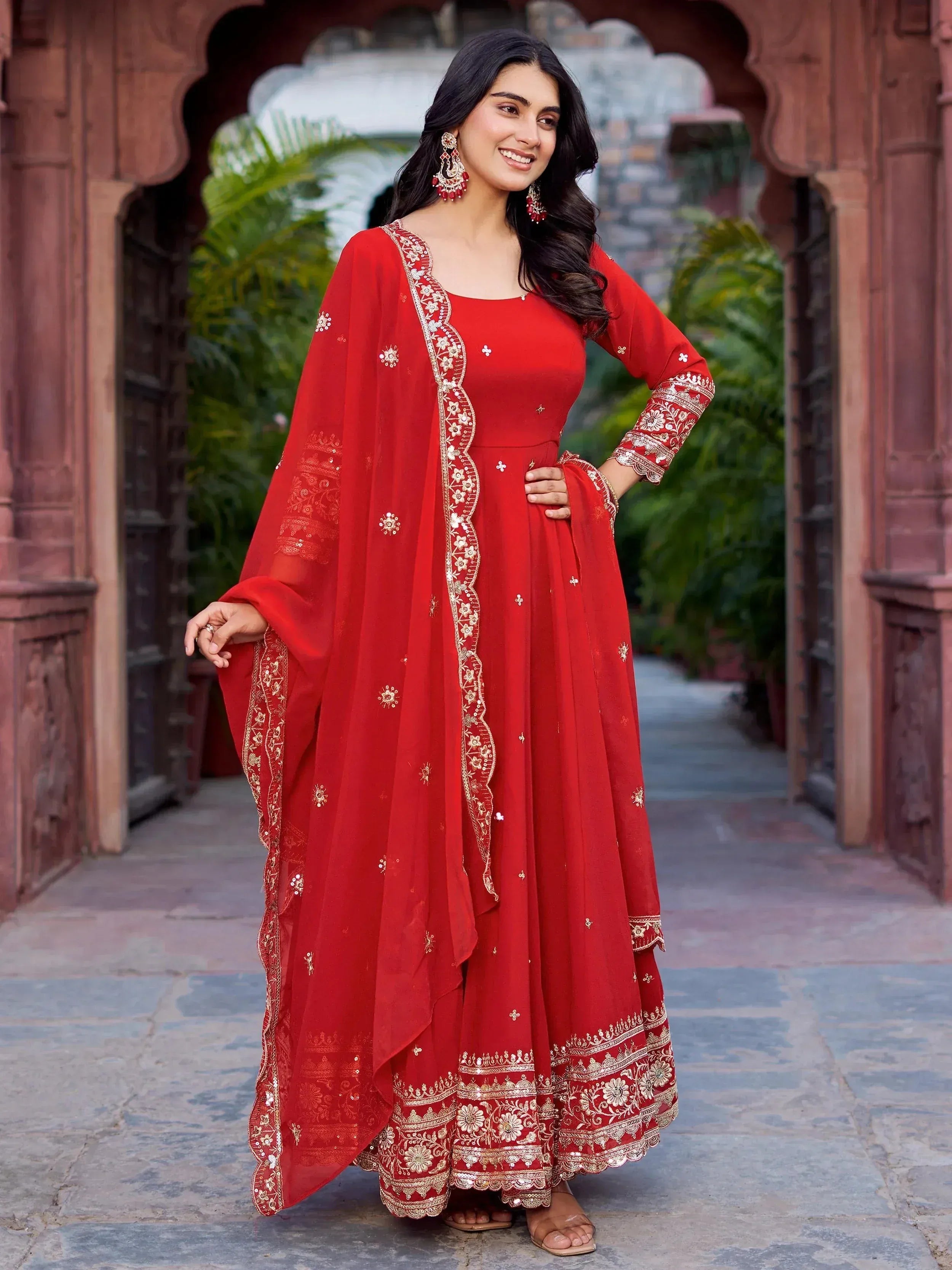 Red embroidered ethnic gown with gold detailing, perfect for Indian celebrations and events.