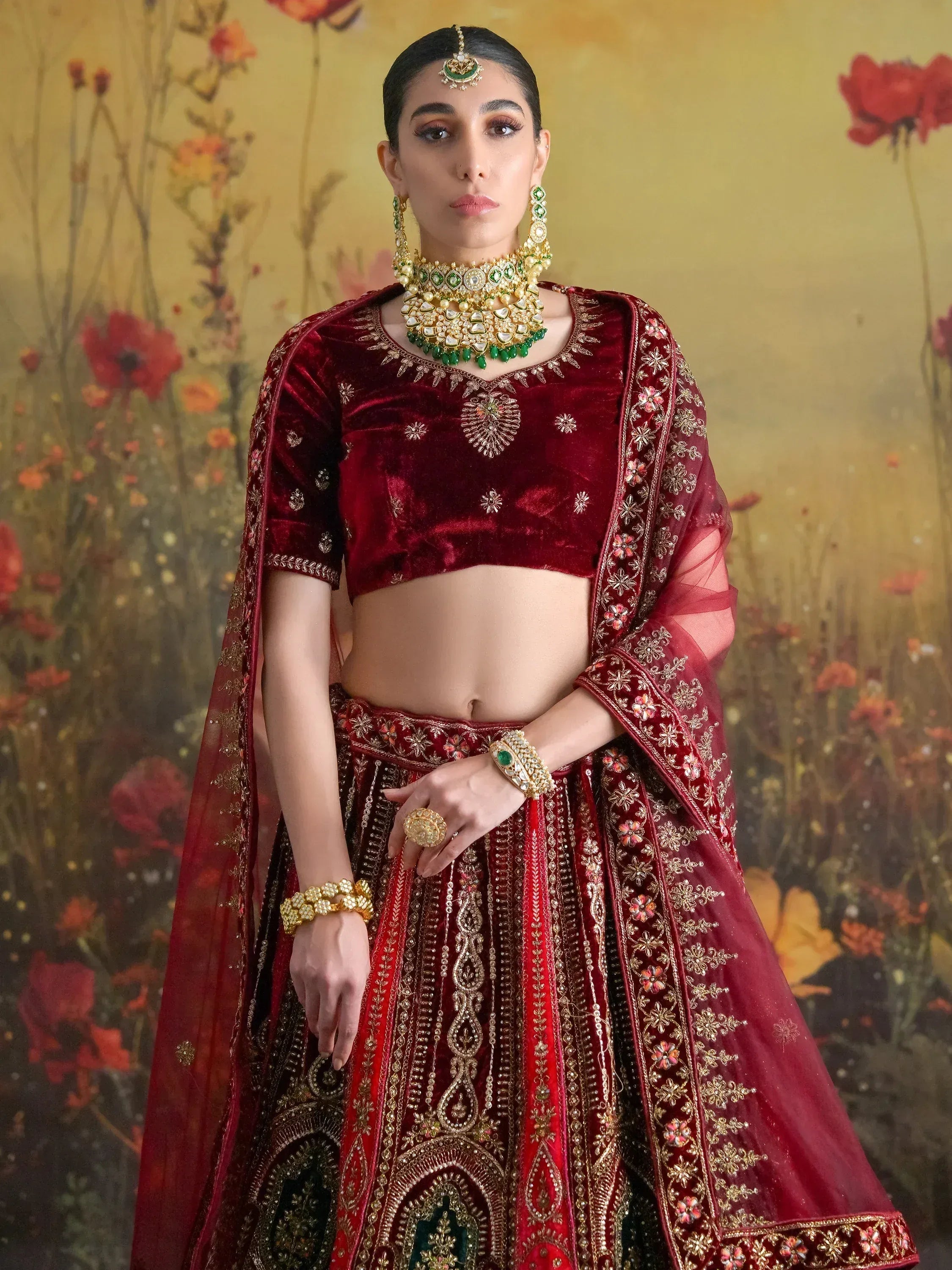 Maroon velvet lehenga choli with gold embroidery, perfect for Indian weddings and festive occasions.