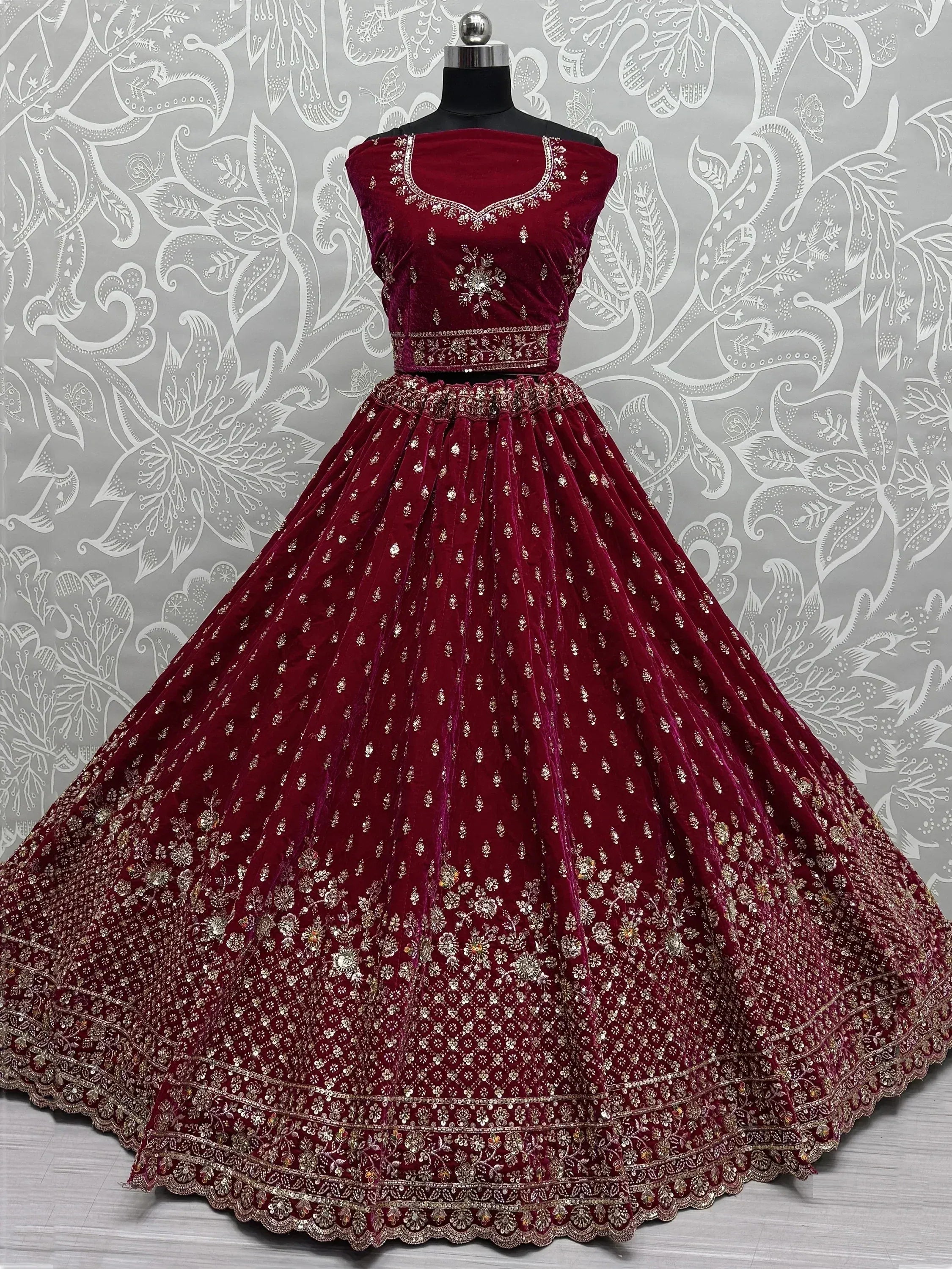 Burgundy velvet lehenga choli with gold embroidery, perfect for Indian weddings and festive occasions.