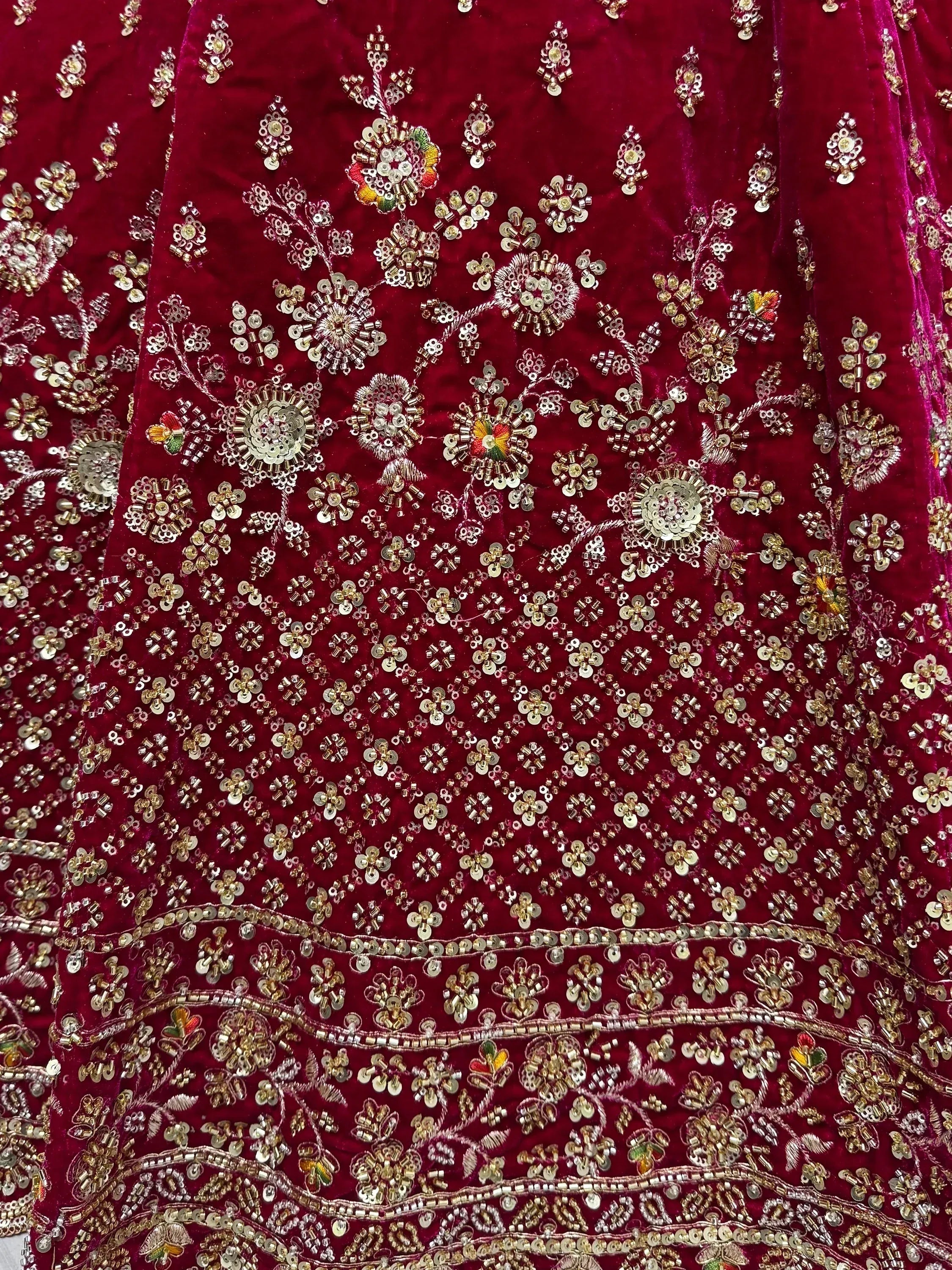Rich maroon velvet lehenga with intricate gold sequin and floral embroidery, perfect for Indian ethnic wear.