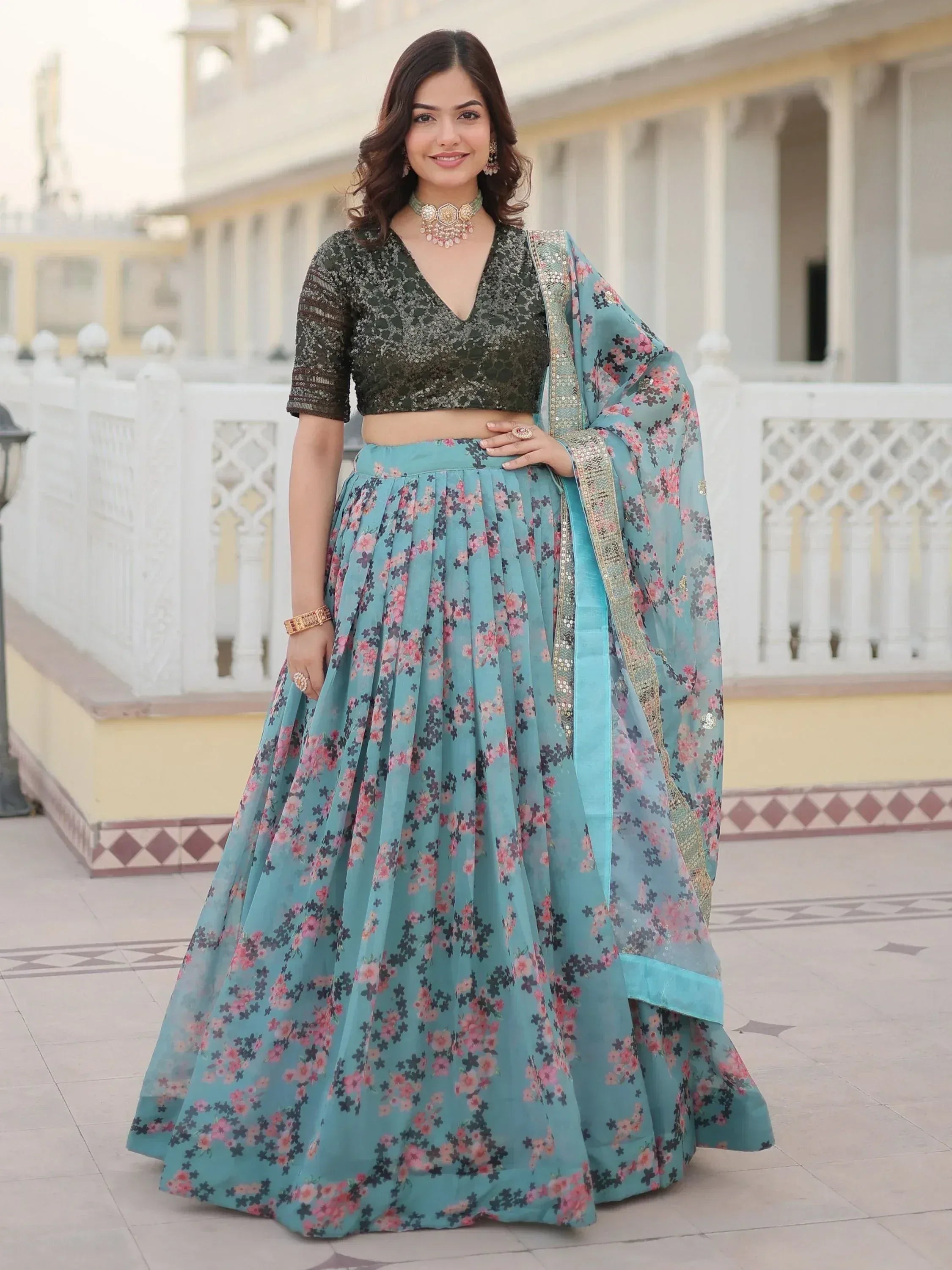 Woman in teal floral lehenga choli with sequined olive green blouse, perfect for Indian ethnic wear occasions.