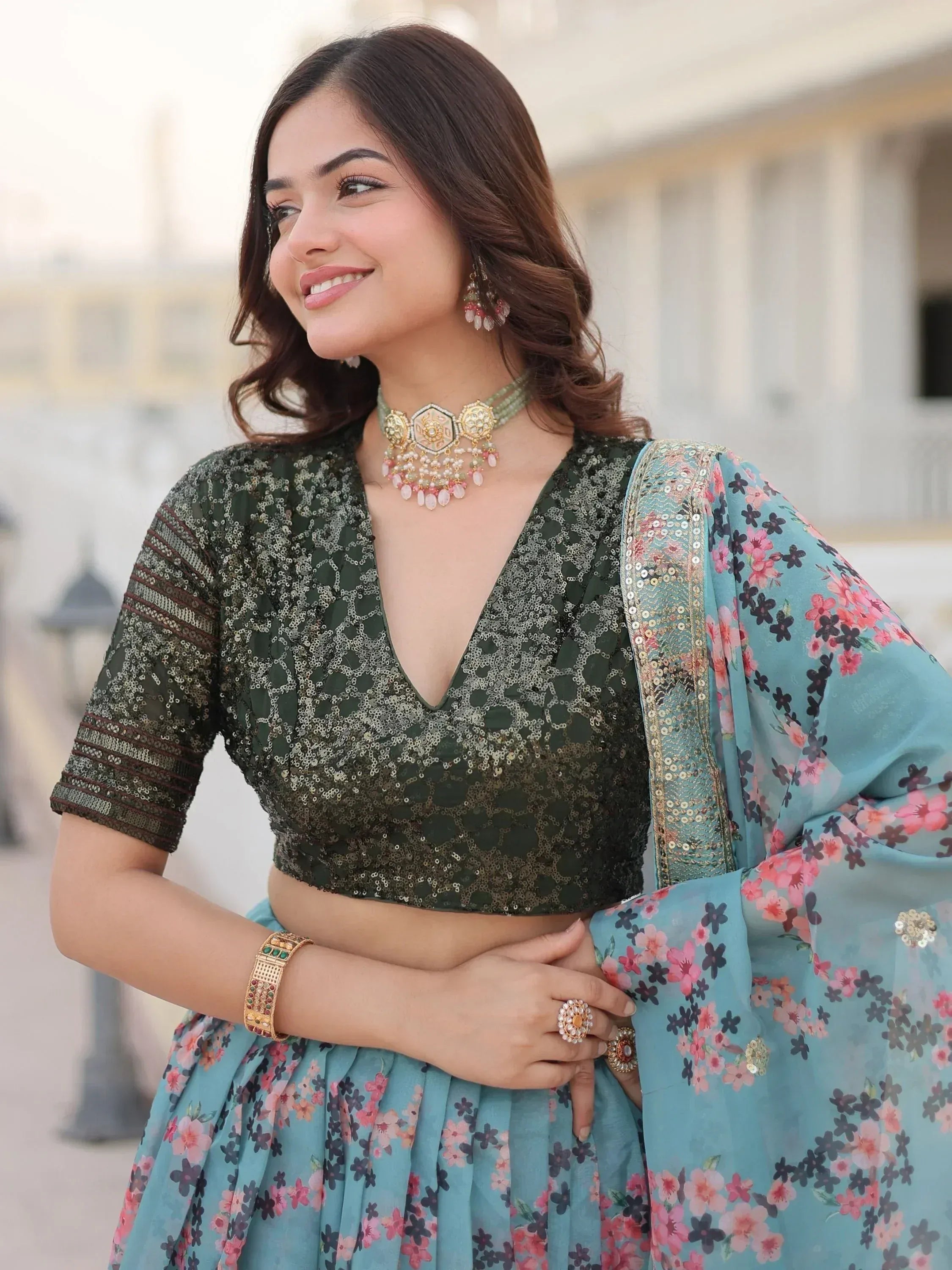 Woman in floral lehenga choli with sequin blouse and traditional jewelry